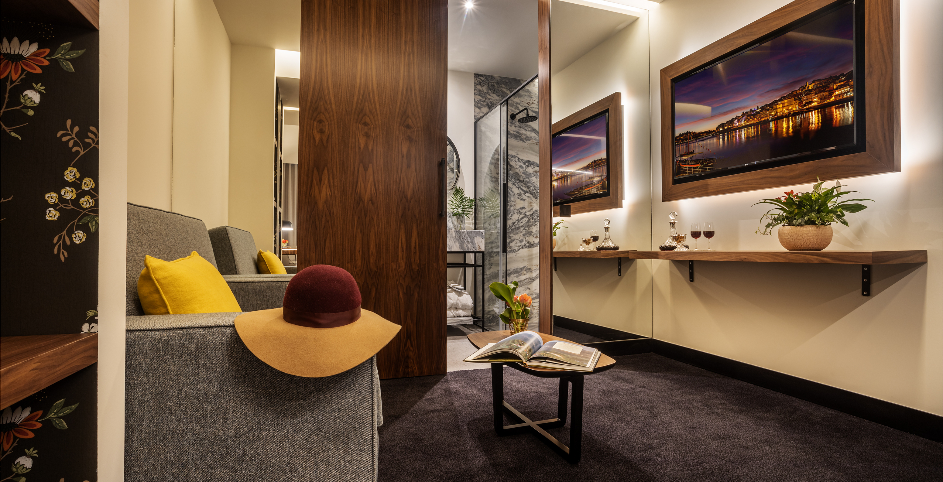 The Junior Suite of The Porto Inn - Rua das Flores has a sofa by the bathroom, with a TV in front