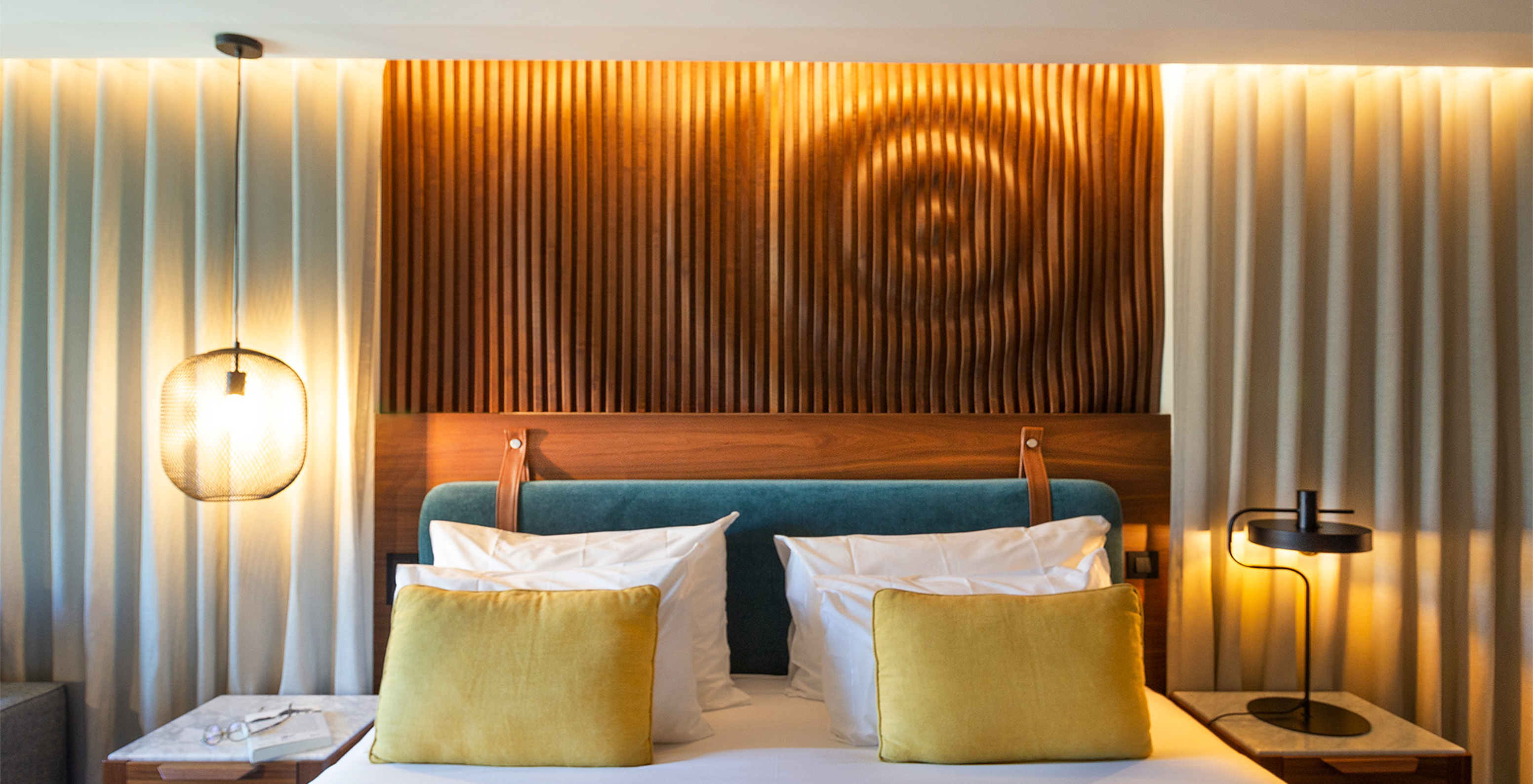 The Superior Family Room of The Porto Inn - Rua das Flores has a turquoise double bed, white sheets, and a wooden headboard