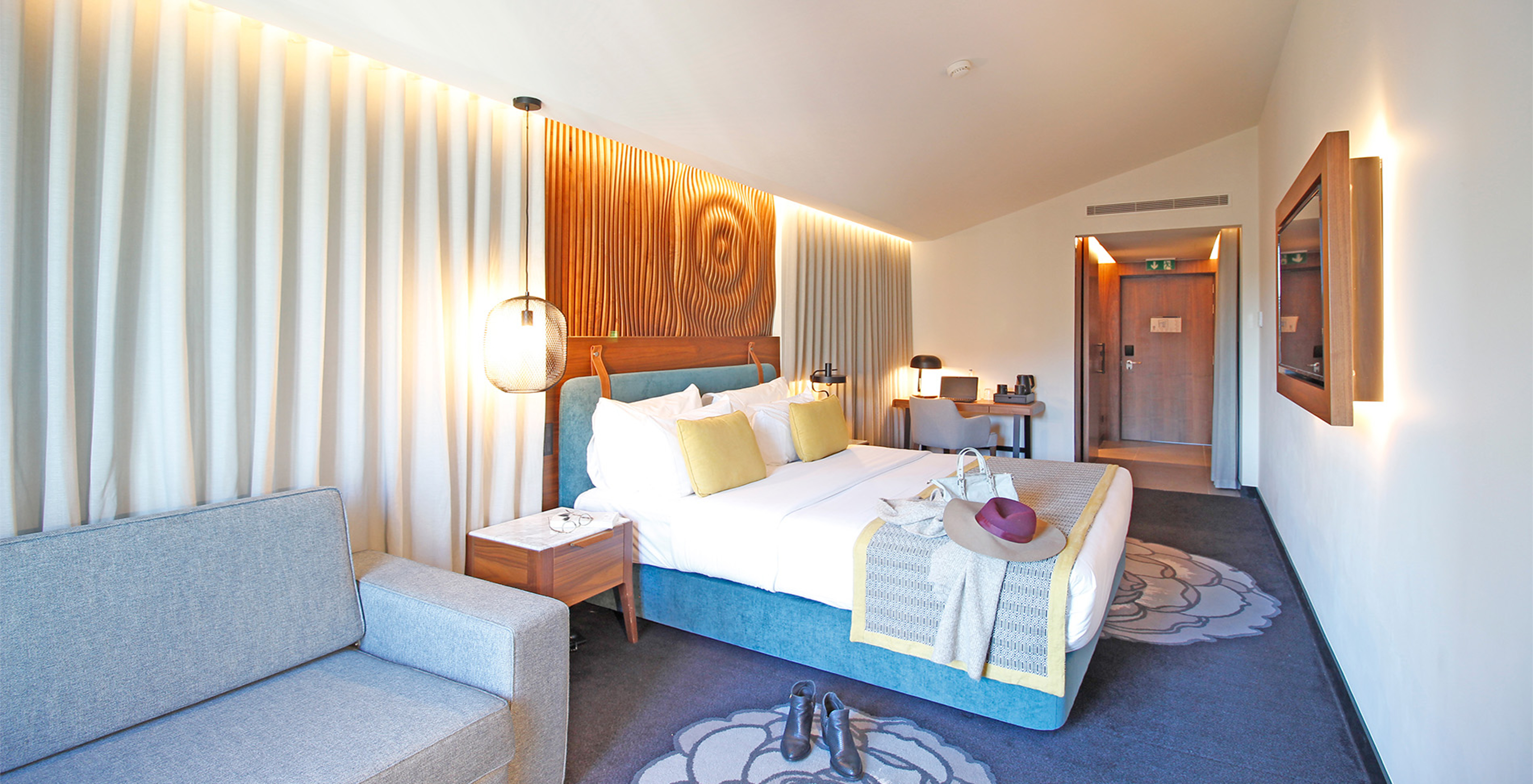 The Superior Family Room of The Porto Inn - Rua das Flores has a sofa and a TV mounted in front of the bed