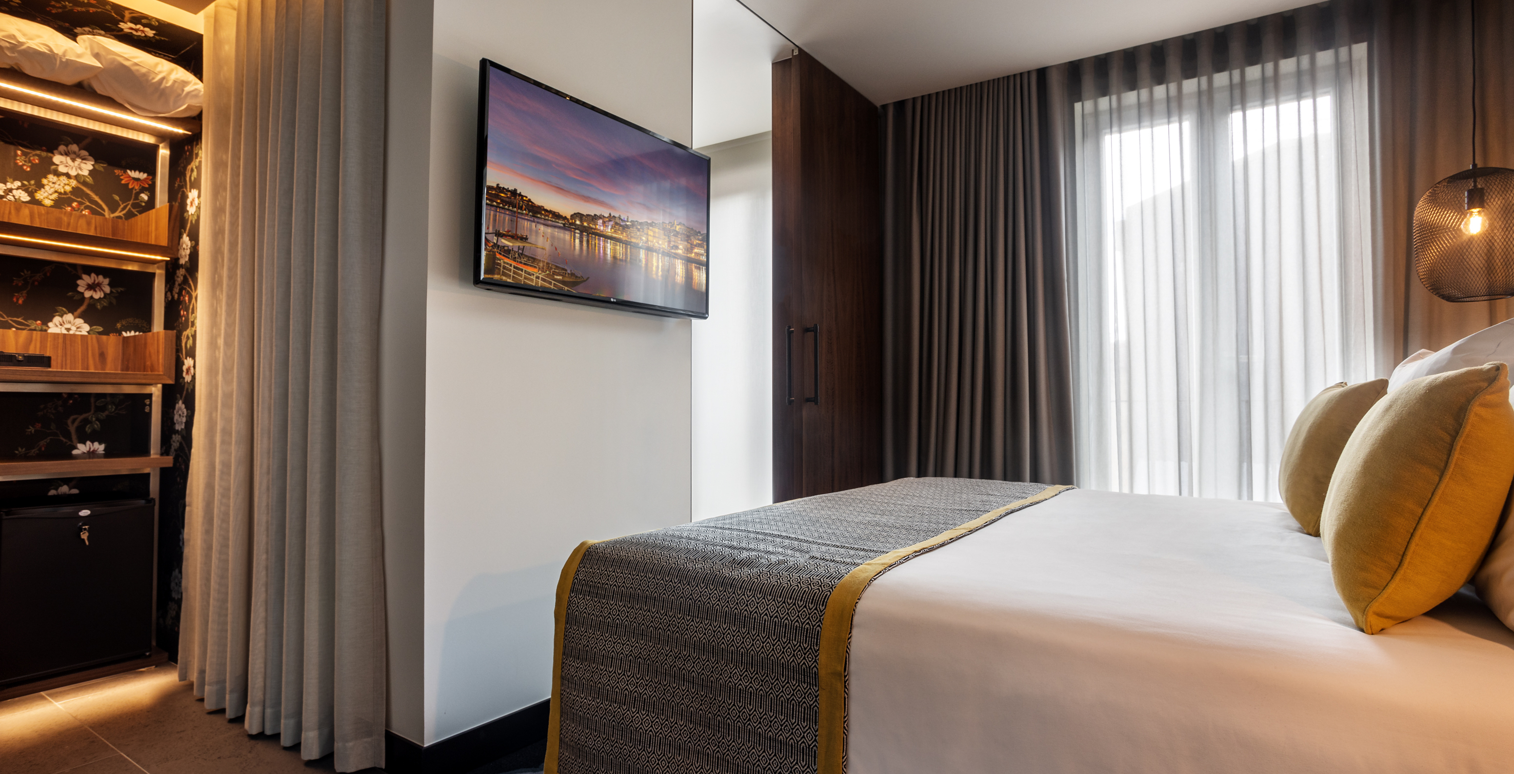 The Superior Room of The Porto Inn - Rua das Flores has a wardrobe with minibar and a TV mounted in front of the bed