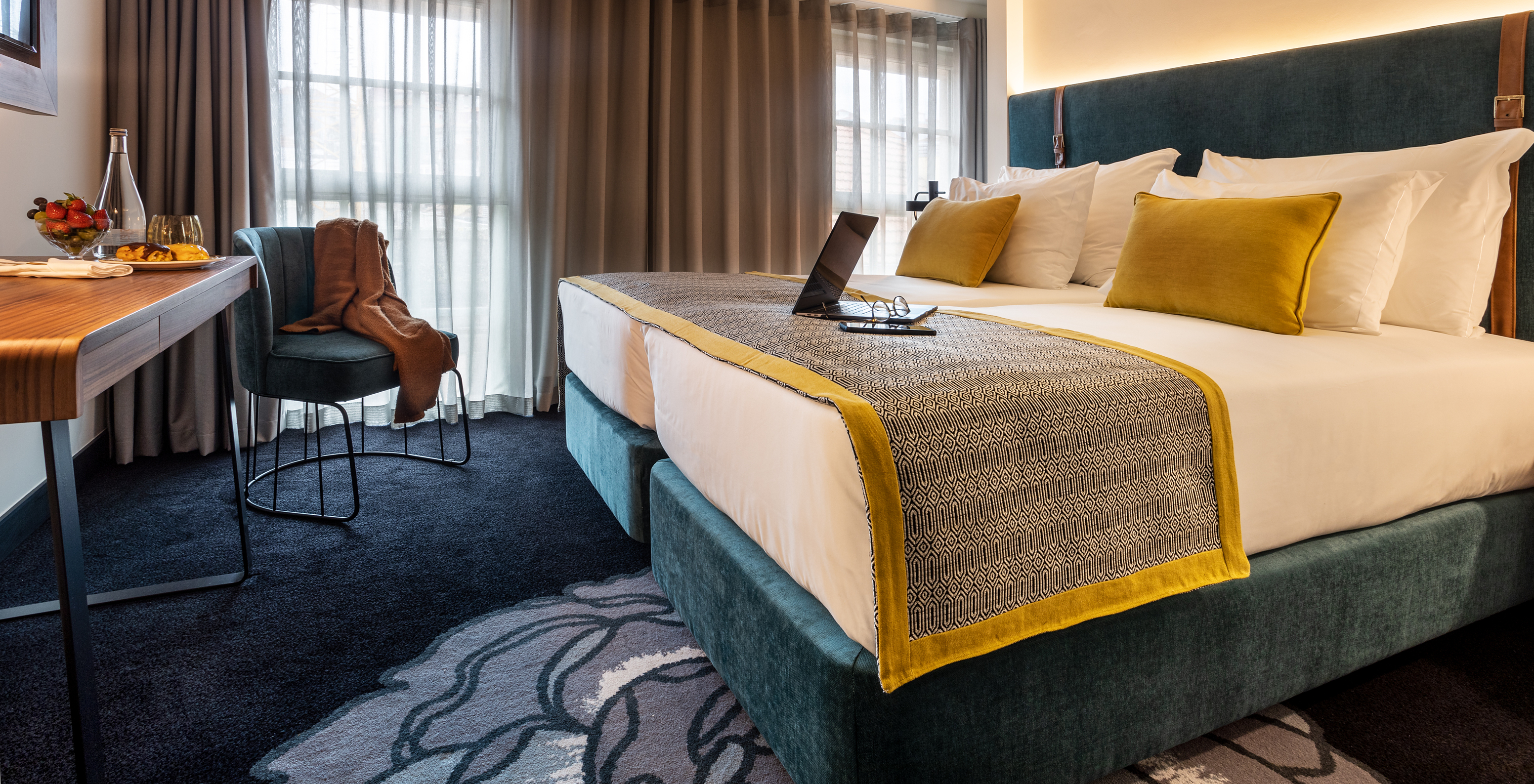 The Superior Plus Room of The Porto Inn - Rua das Flores has a turquoise double bed, white sheets, and a table