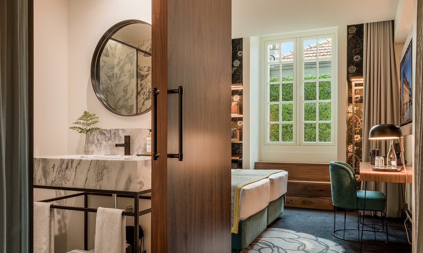 The Cozy Room at Pousada Porto - Rua das Flores is a welcoming room with a bed, desk, television, and bathroom.