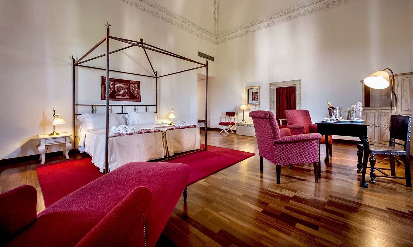 El Suite Especial de la Pousada Castelo Alvito tiene una habitación amplia con dos camas, una mesa con sillas y un sillón