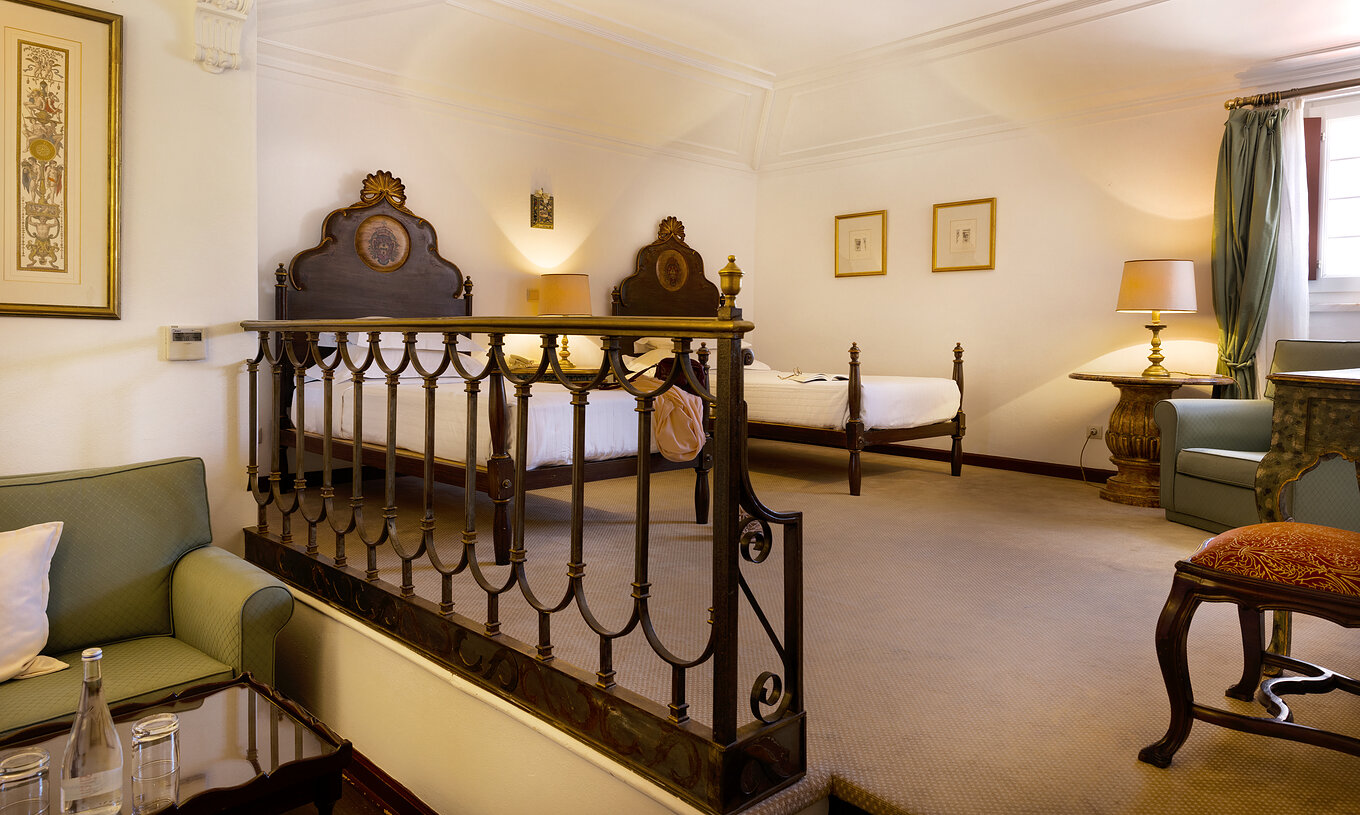 La Familiar Superior tiene dos camas, mesilla, sofá y sillón en la Pousada Castelo Estremoz