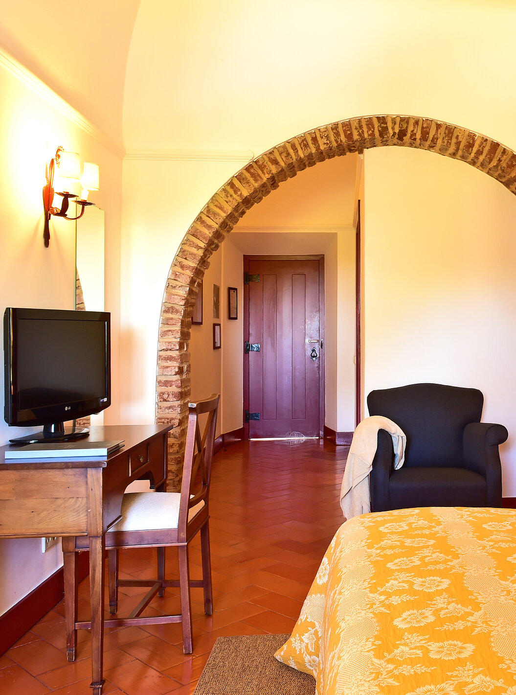 La Standard Suite de la Pousada Convento Beja tiene una cama de matrimonio, con colcha amarilla, una televisión y un sillón