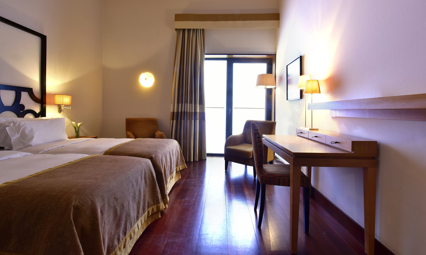 El Cuarto Clásico de la Pousada Convento Tavira tiene dos camas individuales, un escritorio y una ventana con cortinas