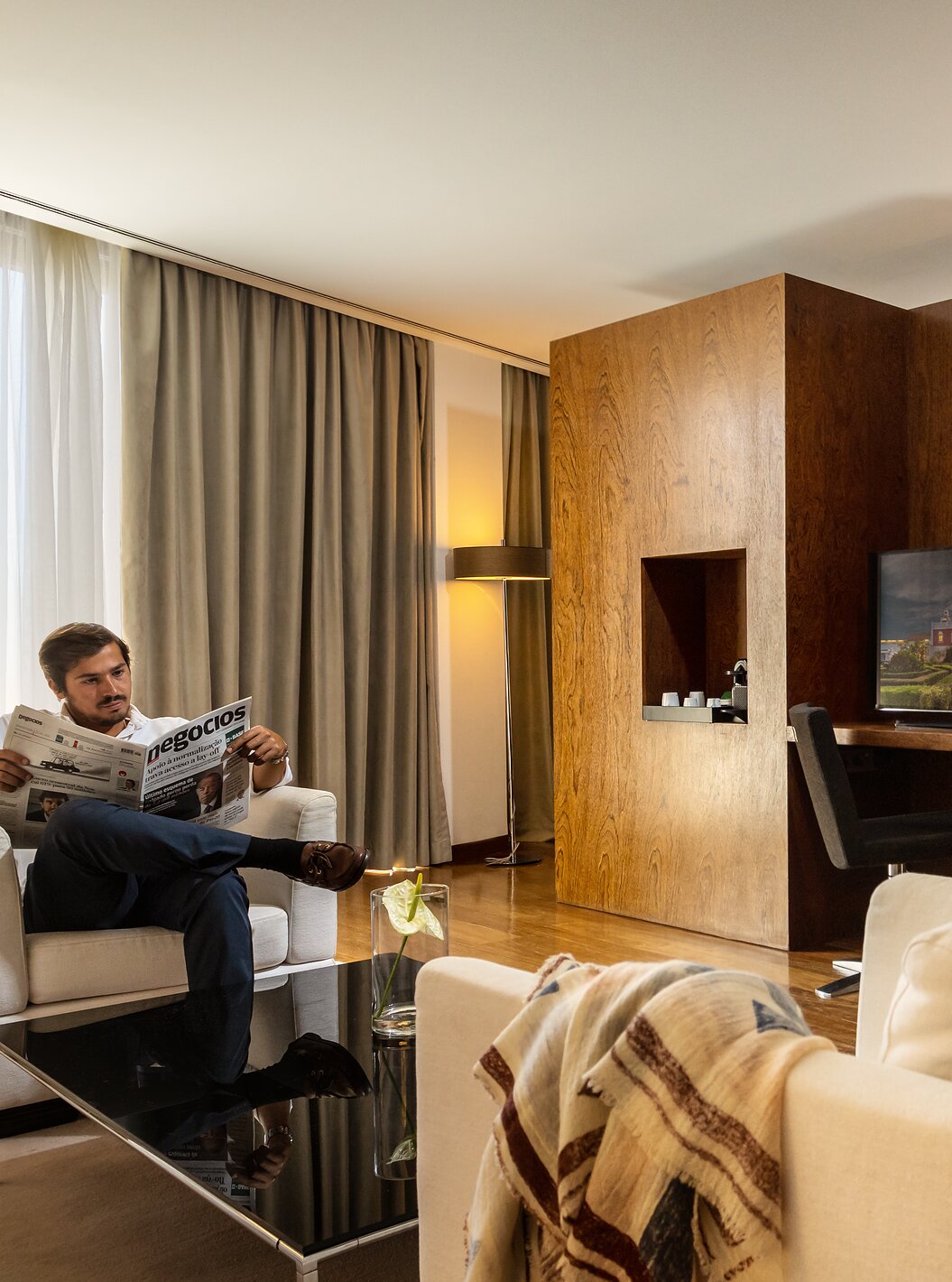La Suite Vista Premium de la Pousada Palácio Estoi con un hombre leyendo y una mujer saliendo de un baño relajante