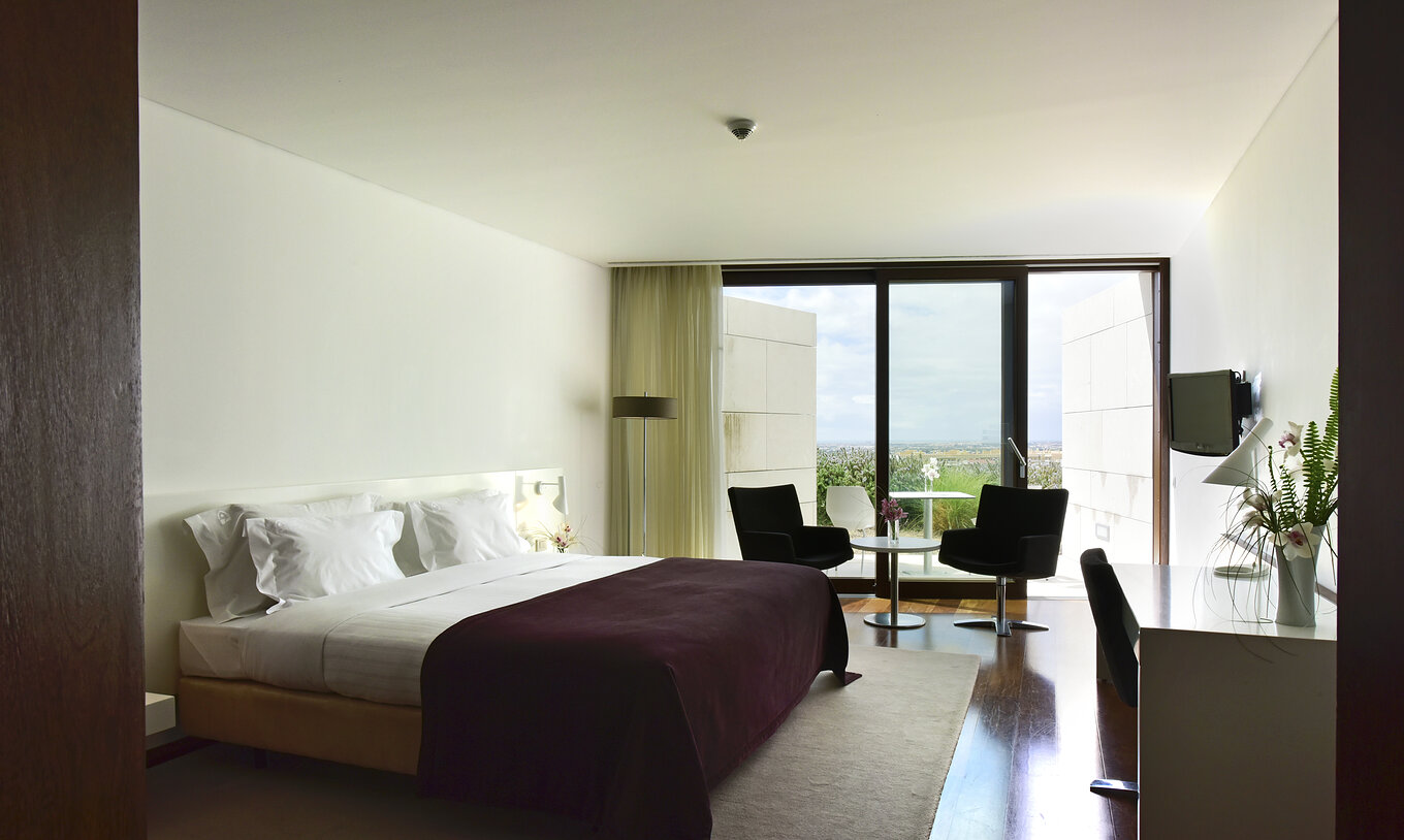 El Superior Premium View de la Pousada Palácio Estoi tiene una cama matrimonial, una mesa con dos sillas y ventana