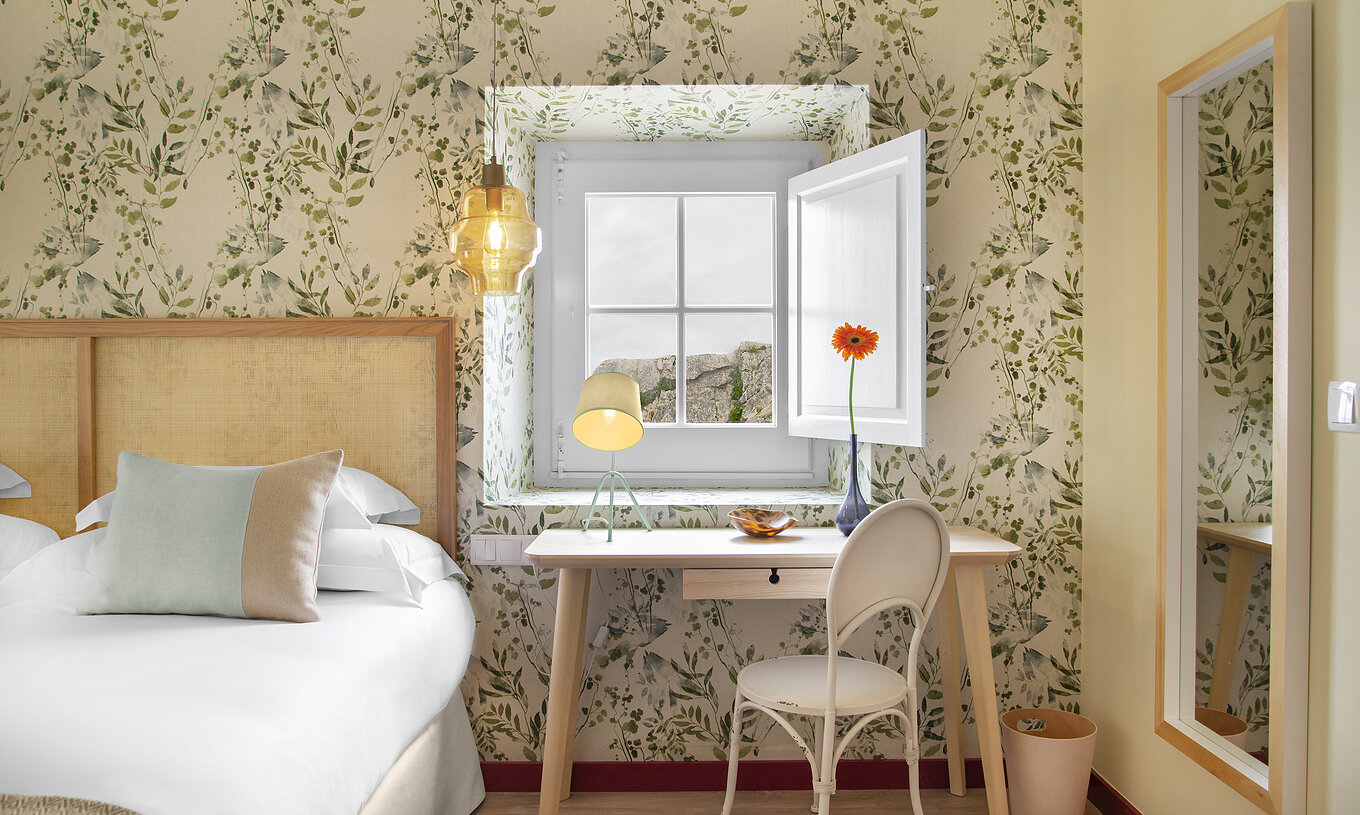 La Habitación Familiar Casa Lidador - Óbidos tiene dos camas, papel tapiz floral y escritorio frente a la ventana