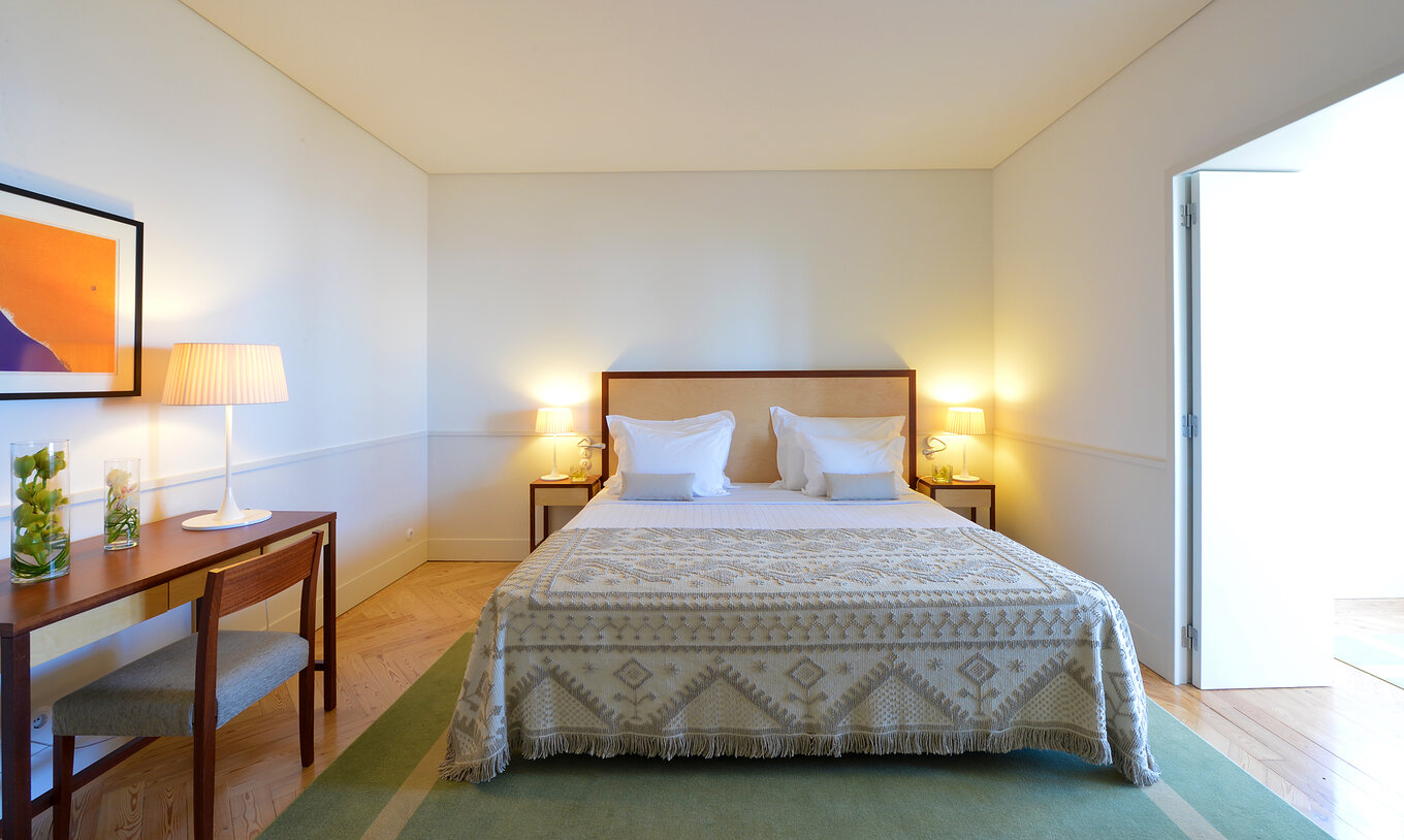 La Junior Suite de la Pousada Serra da Estrela tiene una cama de casal, dos mesas de cabeceira y una secretaría con una silla