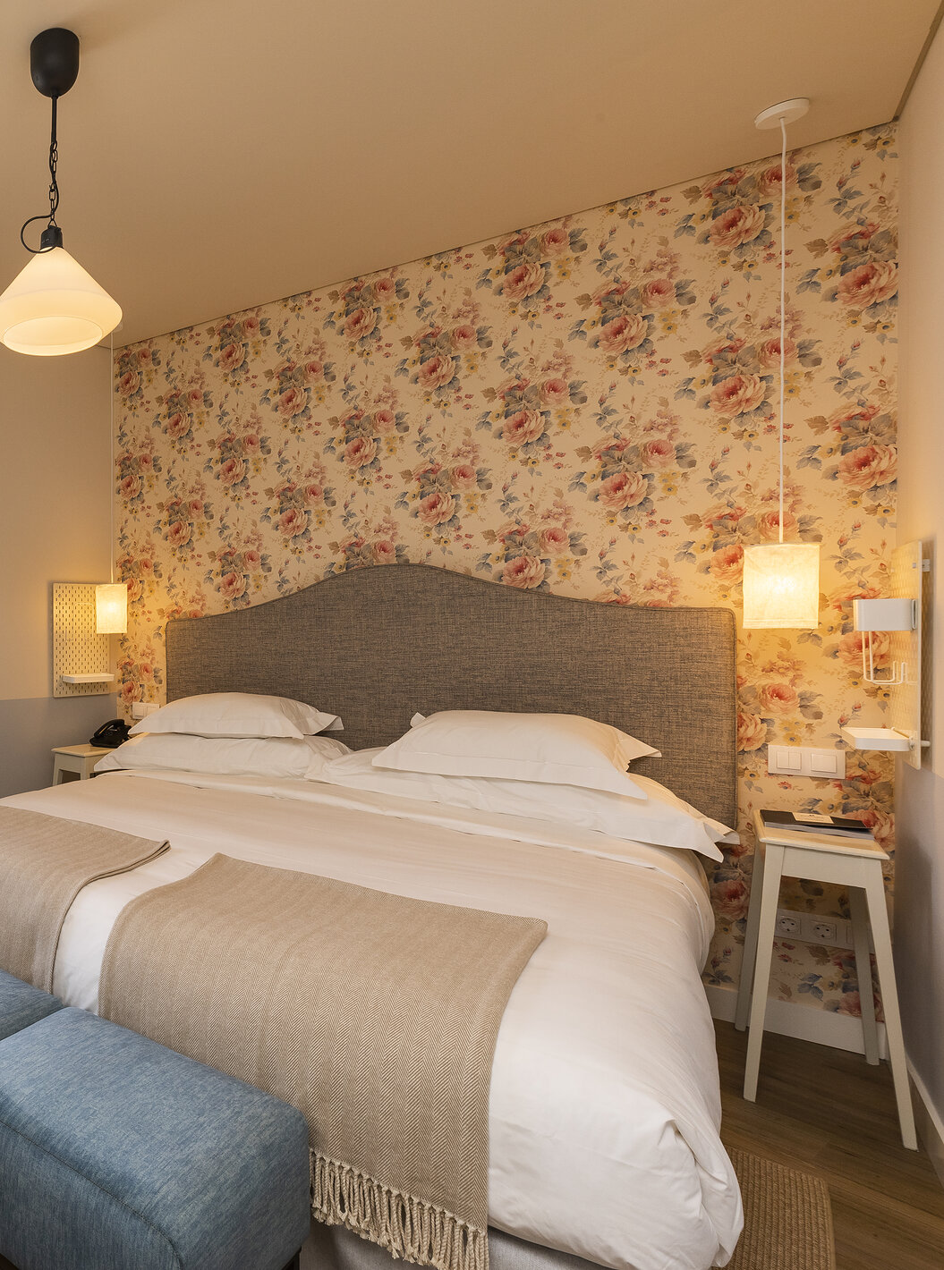 El Cuarto Clásico de la Pousada Vila Óbidos tiene cama de matrimonio y un banco frente a ella, papel tapiz floral y ventana