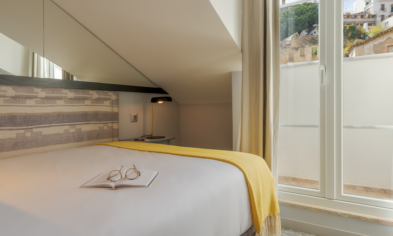 El Mansarda Room de la Pousada Alfama tiene una ventana, al fondo del cuarto, con vista a la parte histórica de la ciudad