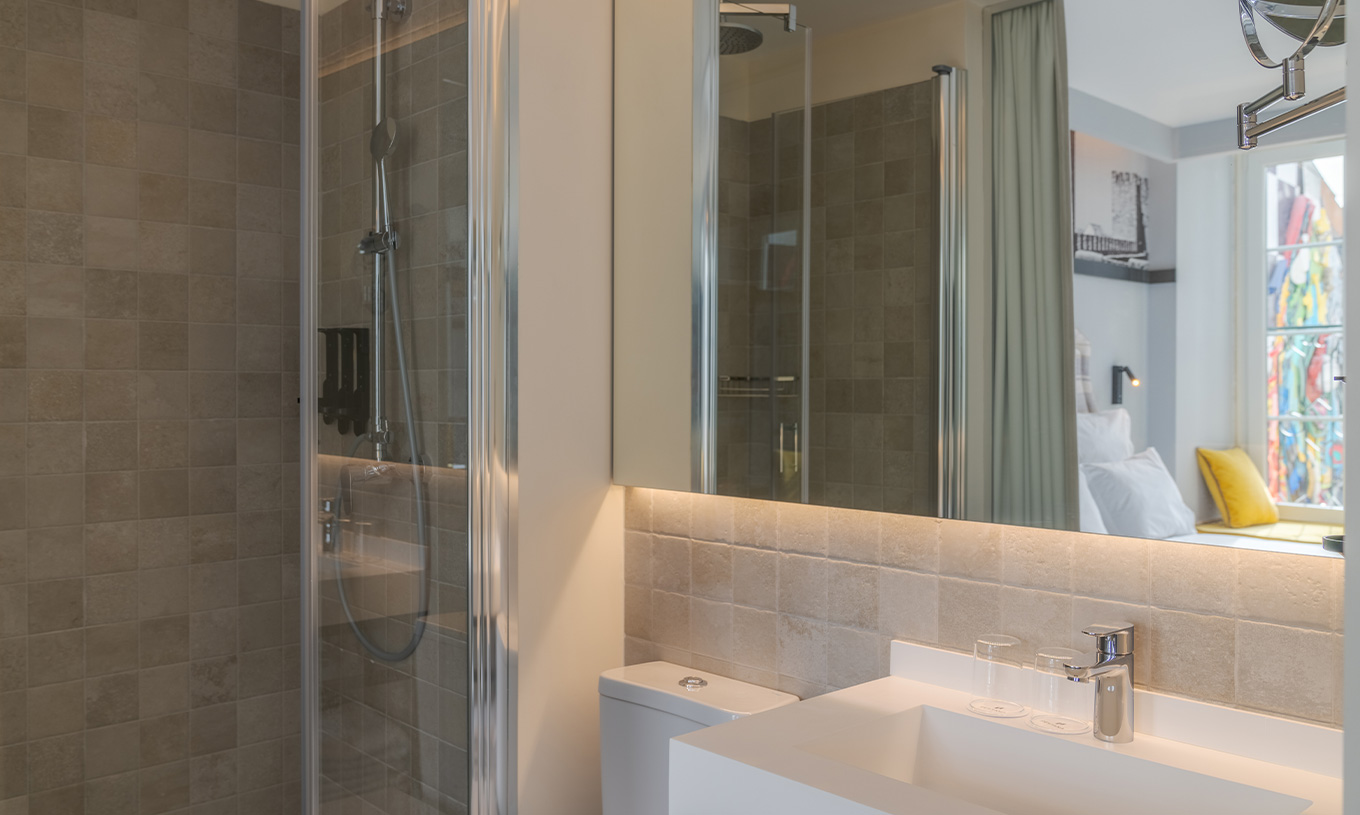 El Superior River View de la Pousada Alfama tiene una ducha a ras de suelo y un amplio lavabo en el baño