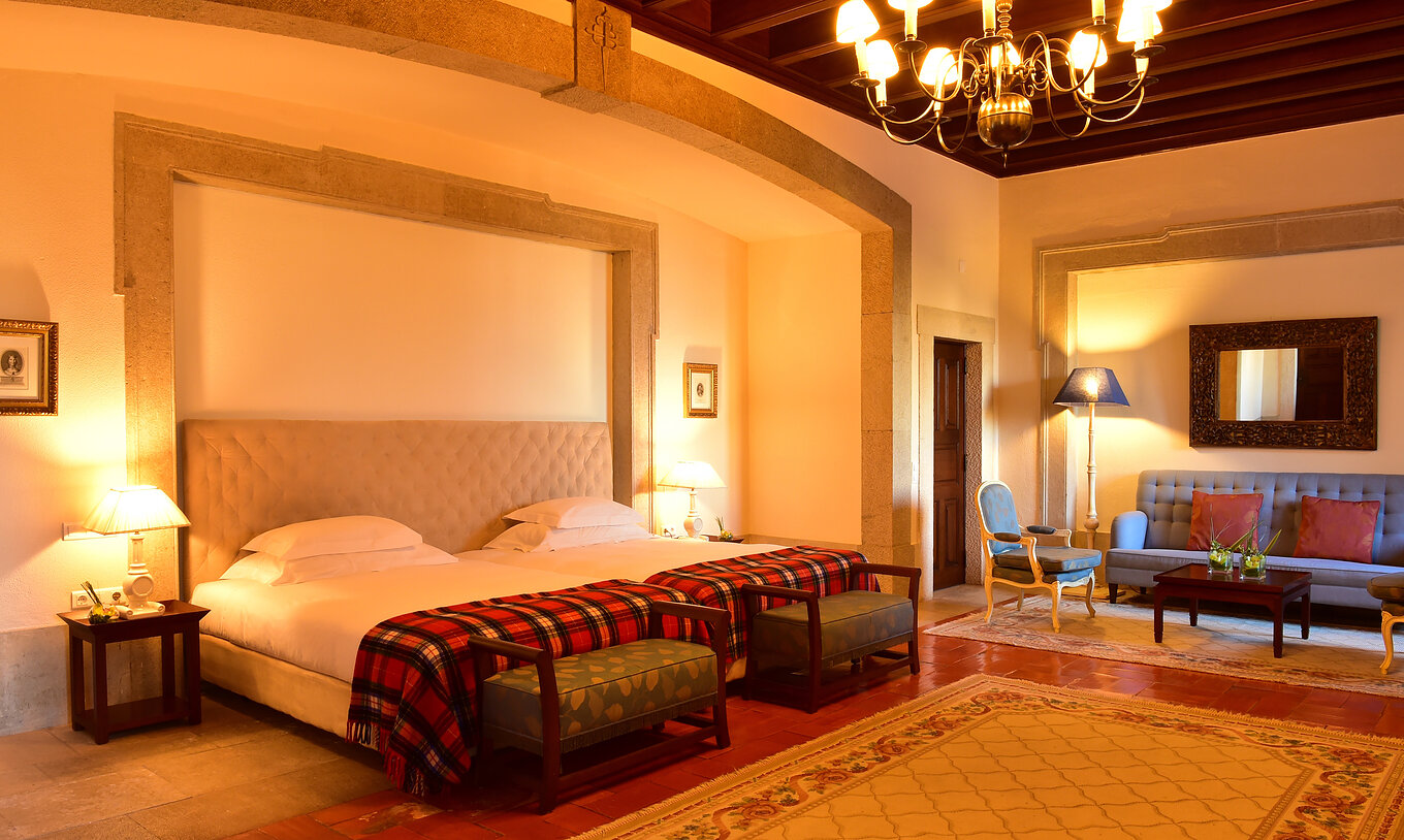 La Suite Especial de la Pousada Castelo Palmela tiene dos camas individuales, un candelabro dorado, un sofá y una silla