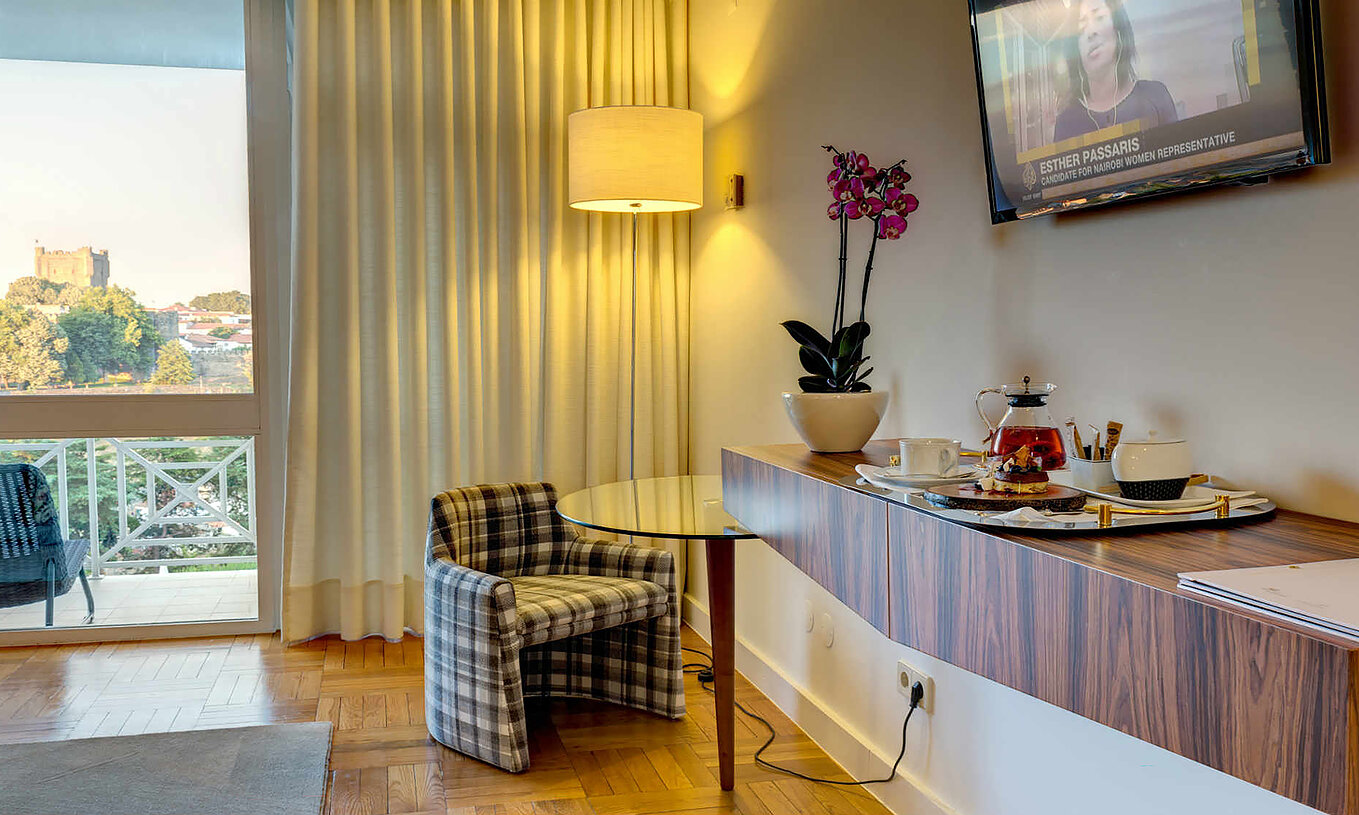 La Habitación Clásica de la Pousada Bragança tiene una televisión, una mesa suspendida con comida y un sillón con mesa