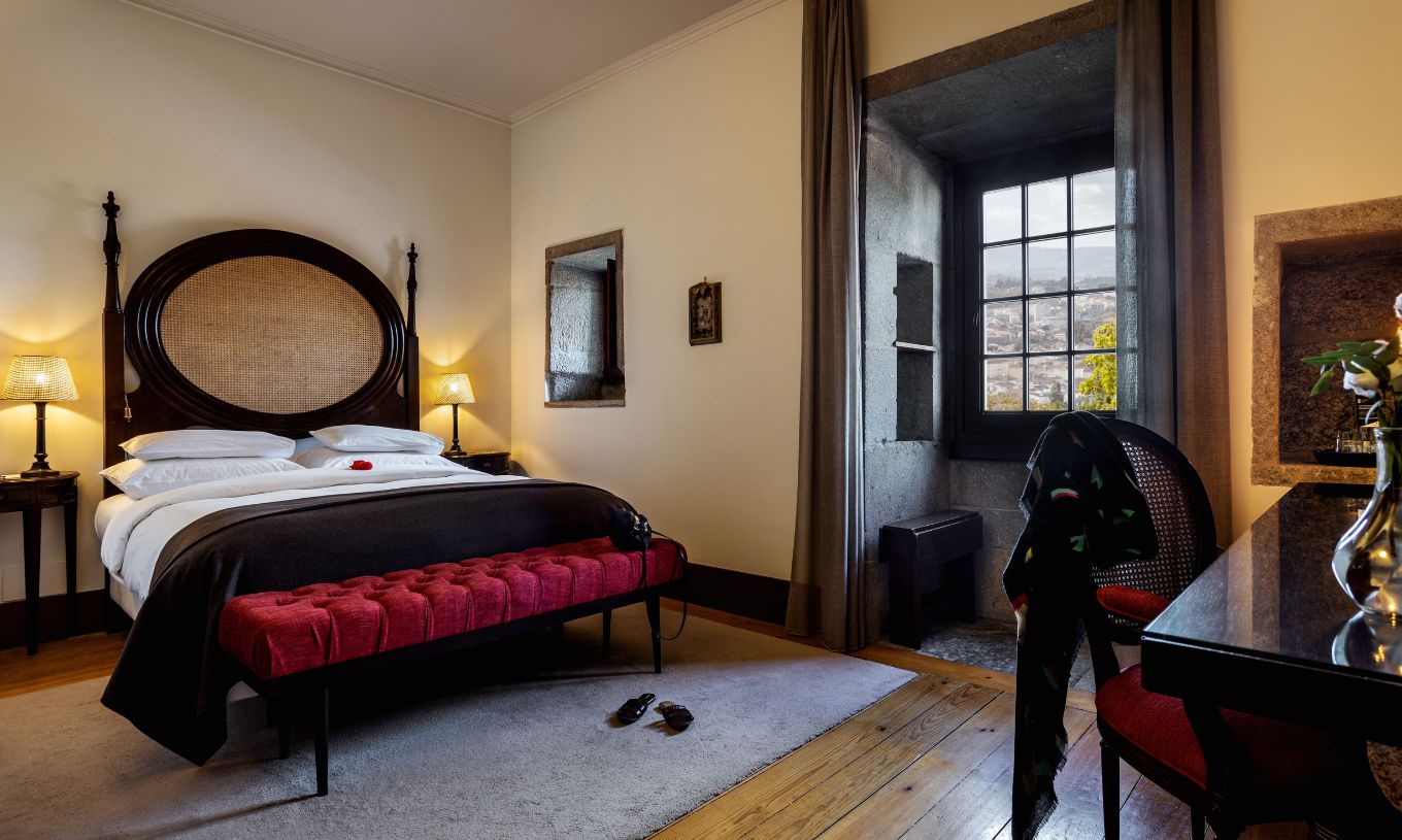 El Cuarto Clásico de la Pousada Mosteiro Guimarães tiene una cama matrimonial con cabecera de madera oscura y mimbre