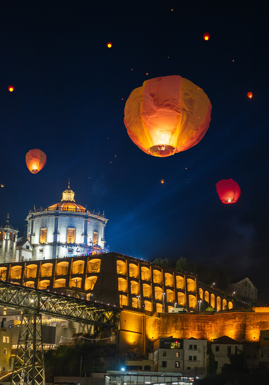 Festival de San Juan en Oporto con faroles iluminados sobre edificios históricos junto al río Duero