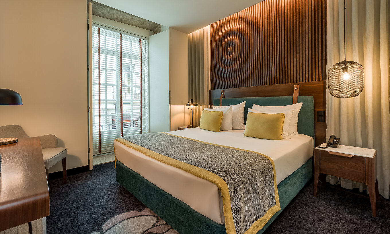 El Deluxe de la Pousada Porto - Rua das Flores tiene una cama doble grande con cabecero verde y pared de madera