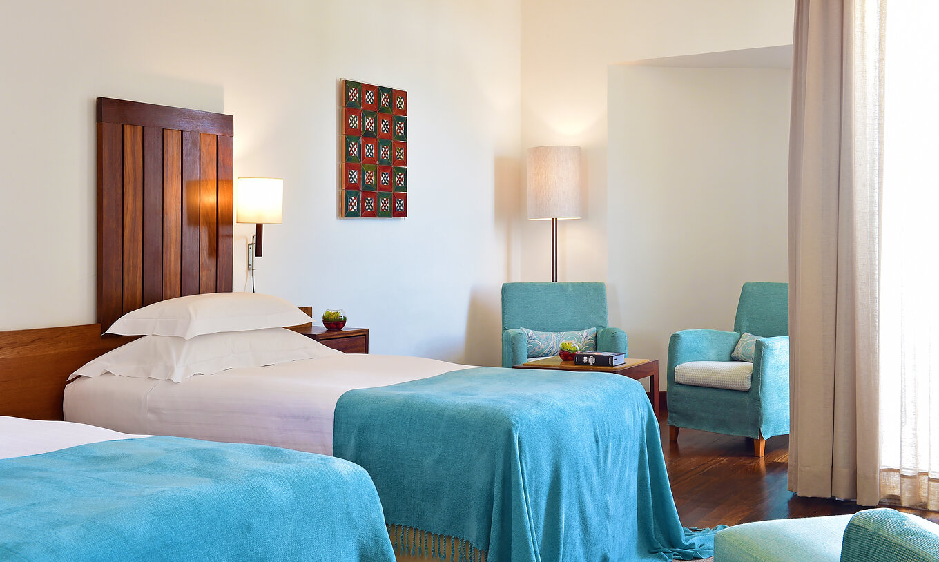 La Habitación Superior de la Pousada Castelo Alcácer do Sal tiene dos camas separadas, con un edredón azul y dos sillones