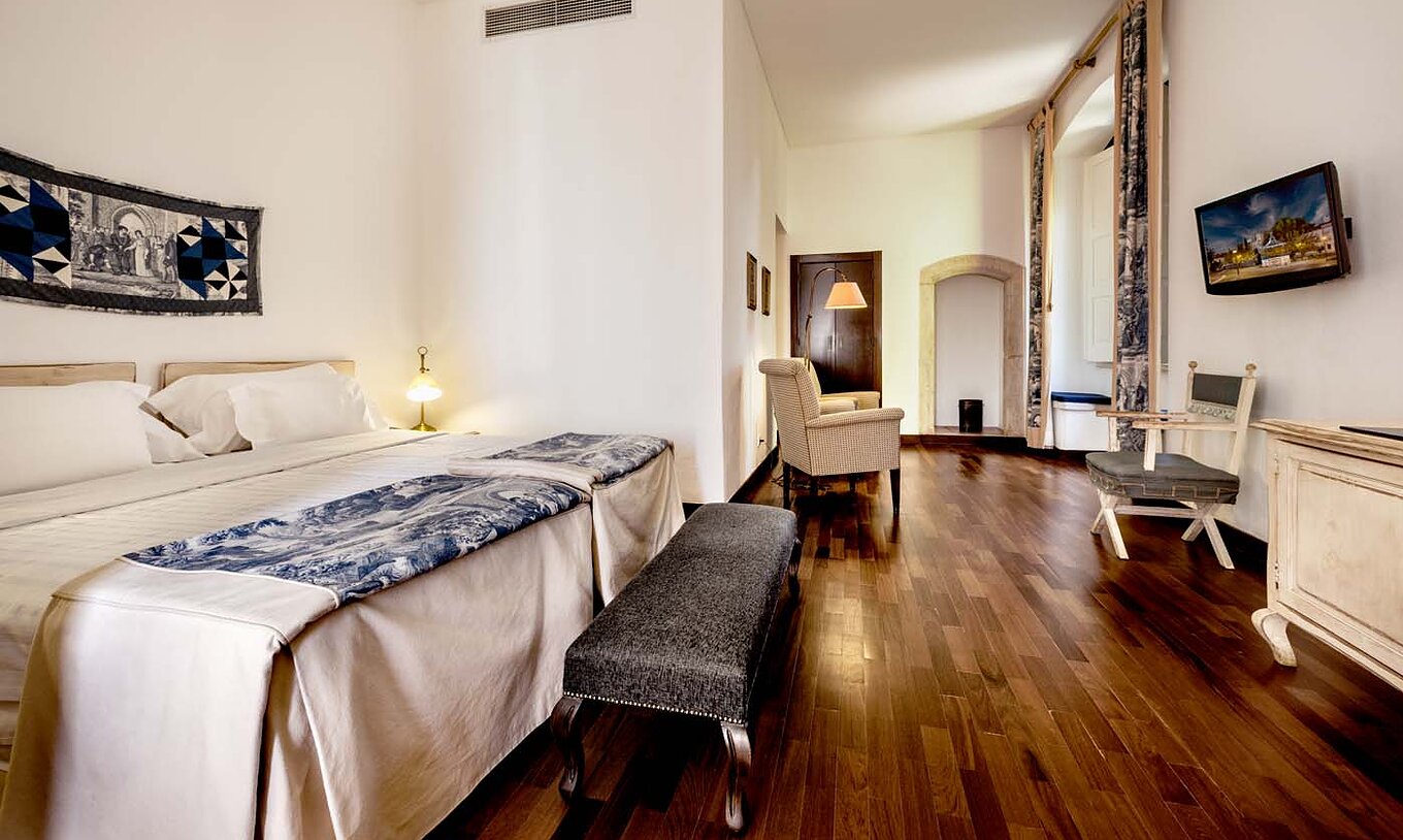 El Large Family de la Pousada Castelo Alvito tiene dos camas, un banco al fondo de la cama, una televisión y sillas