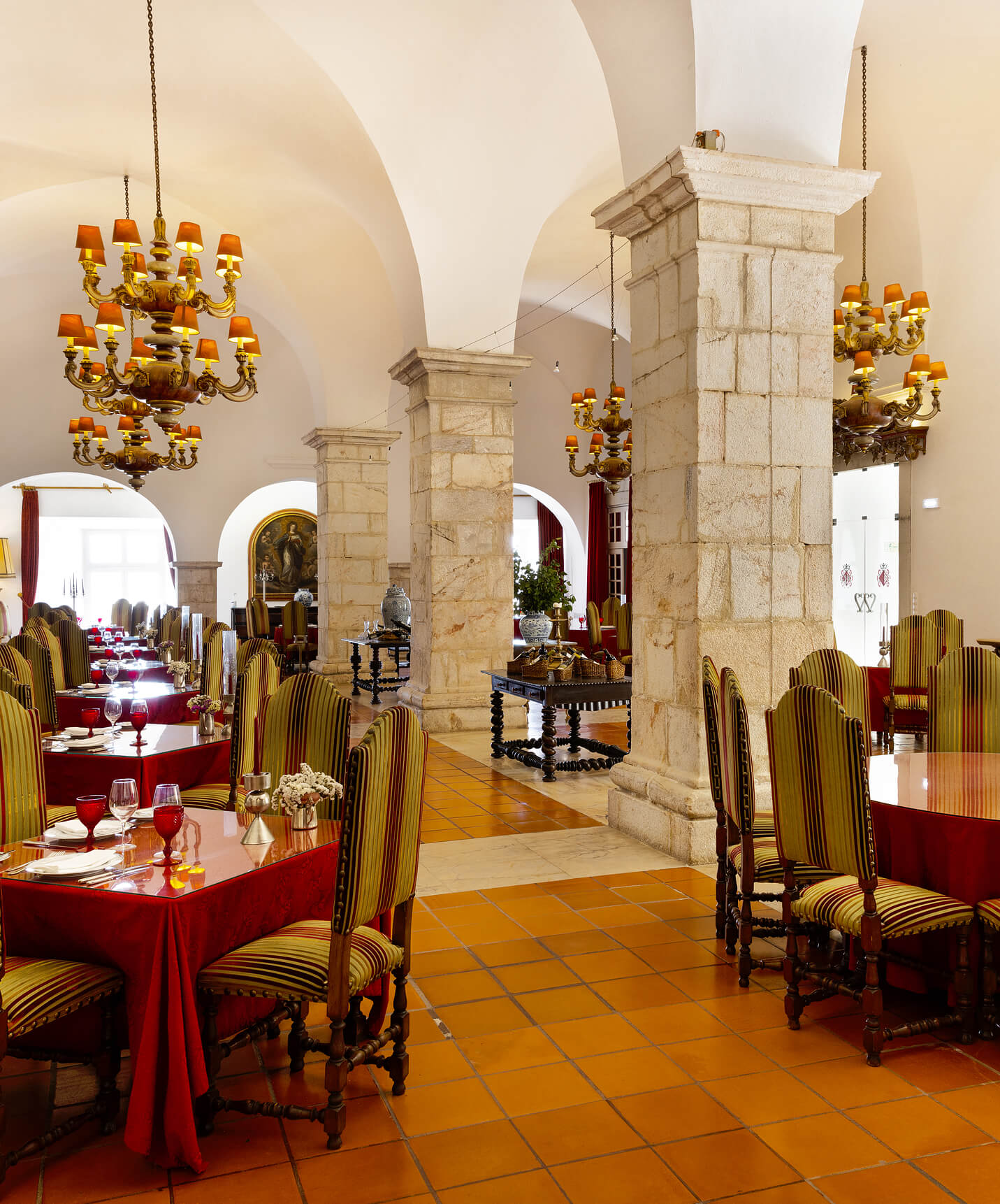 Restaurante del Hotel en el Centro Histórico de Estremoz, con mesas puestas, candelabros clásicos y columnas de piedra
