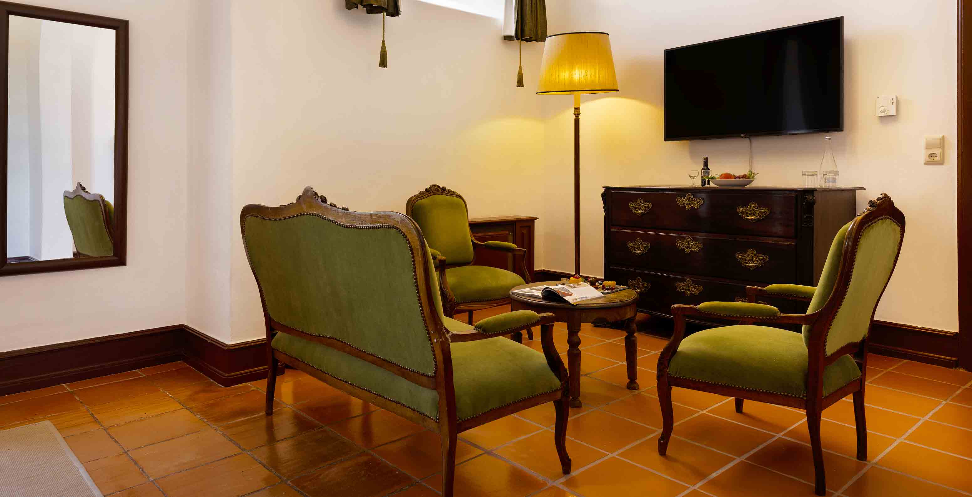 La Junior Suite tiene sala con sofás, un espejo y TV en la Pousada Castelo Estremoz
