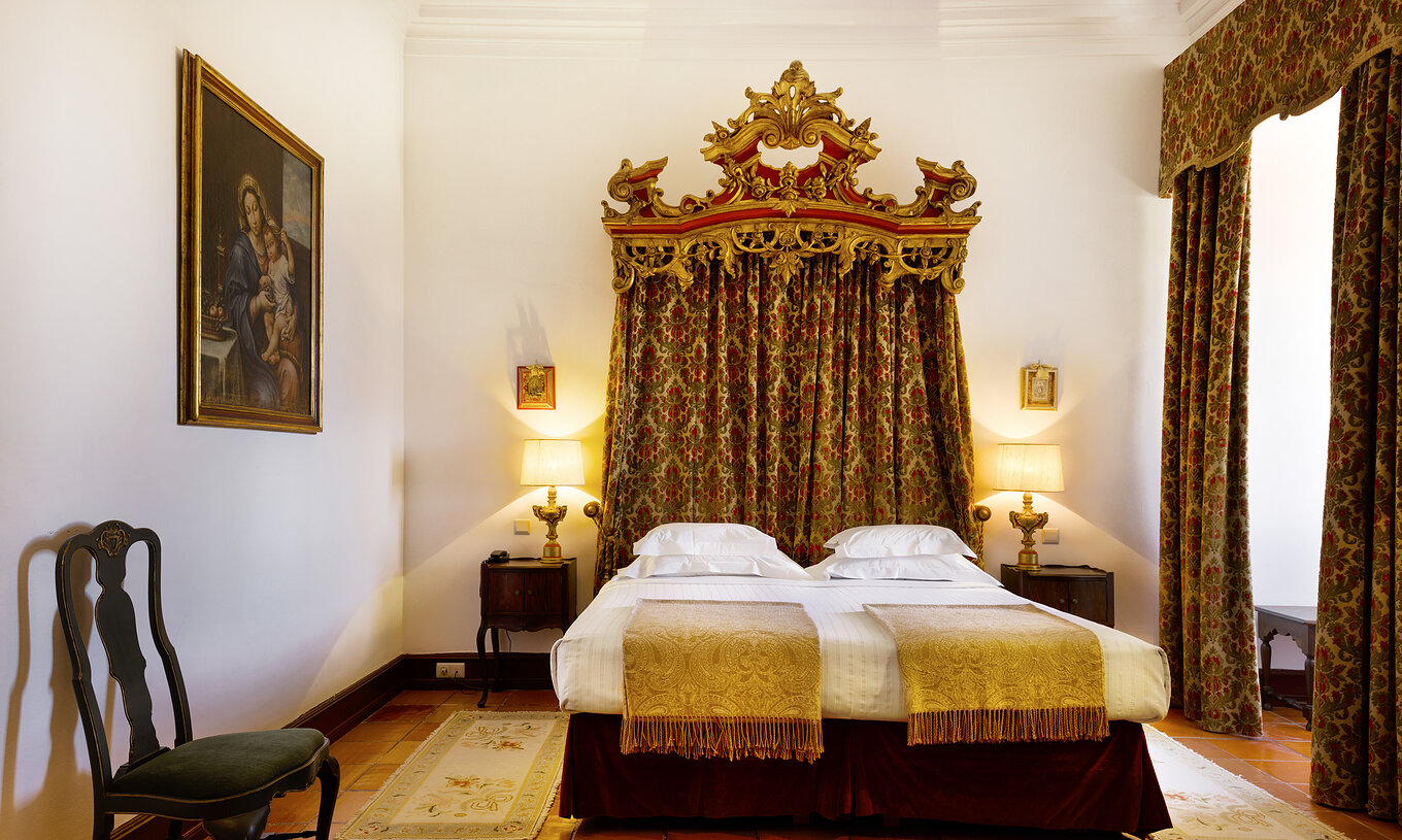 El Special Suite de la Pousada Castelo Estremoz tiene una cama de matrimonio con un cabecero de cortina, y muebles antiguos