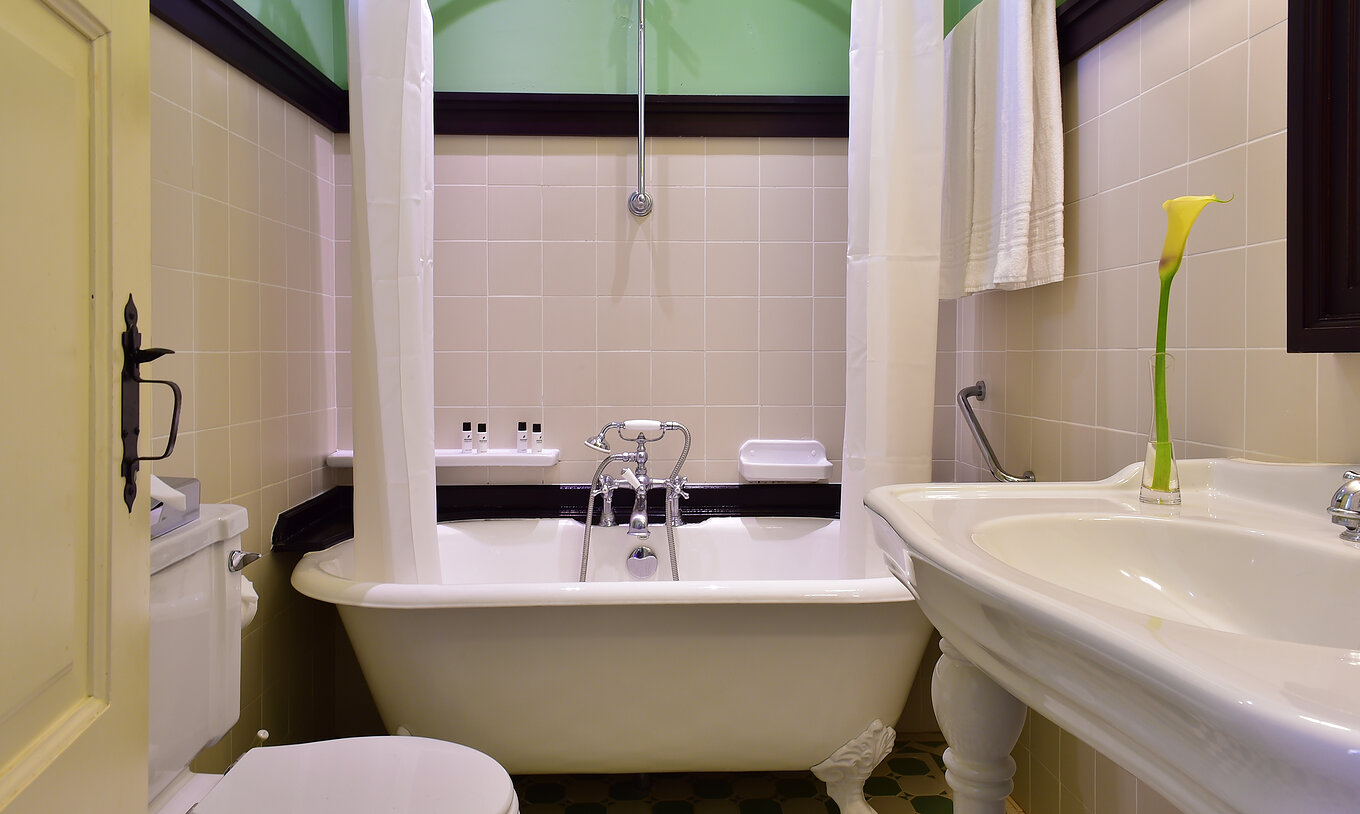 La Suite Especial de la Pousada Convento Évora cuenta con un baño con lavabo y una bañera con cortina