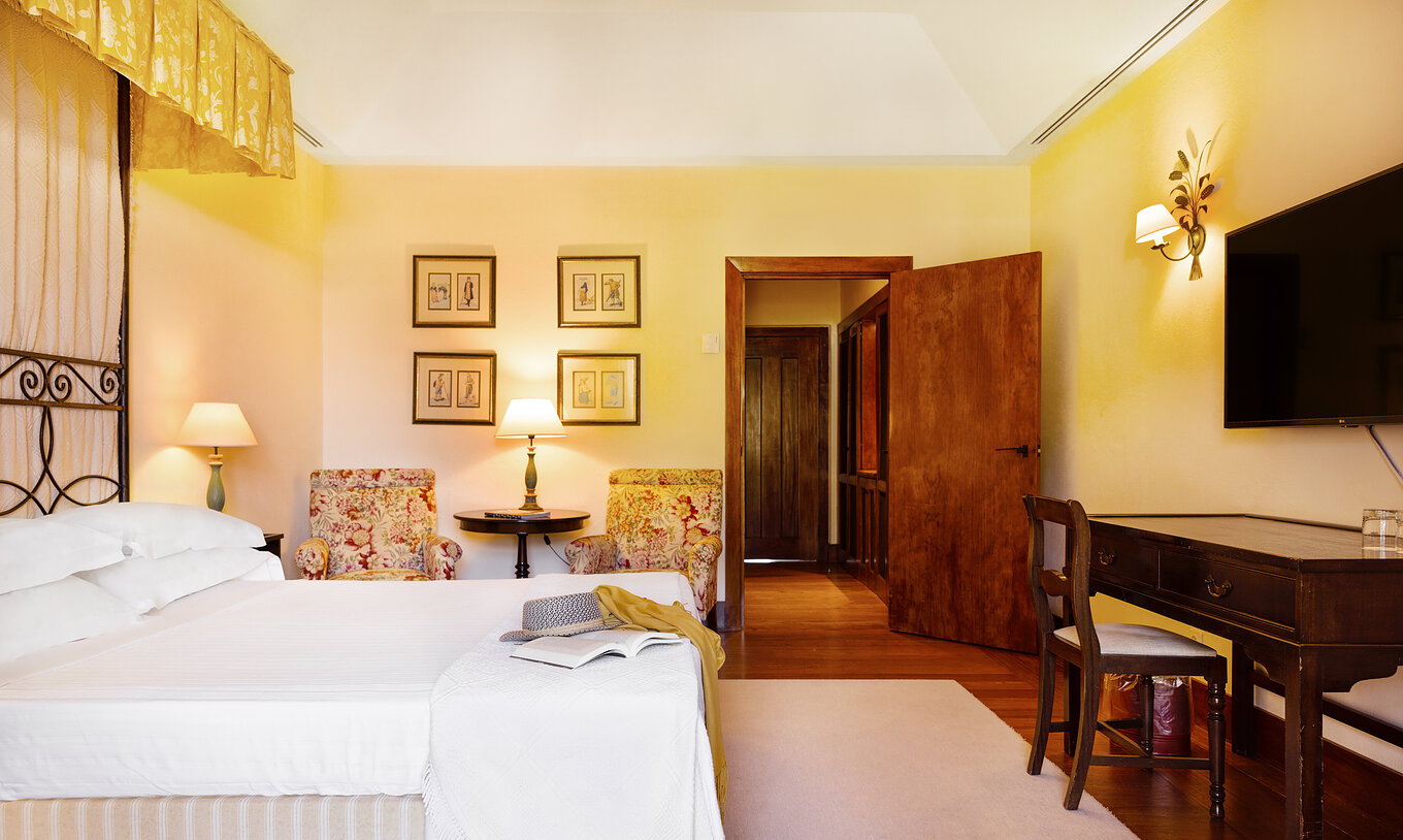 El Large Family de la Pousada Convento Vila Viçosa tiene una cama, con dos sillas, una mesa de apoyo y una televisión