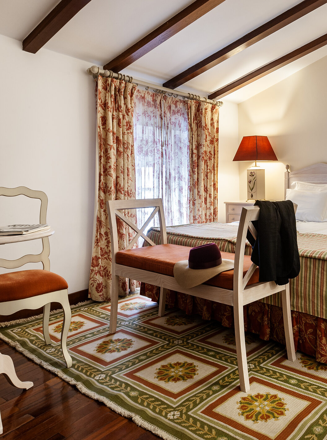 La Suite Superior con Balcón de la Pousada Marvão cuenta con una cama matrimonial, un banco al pie y un sillón