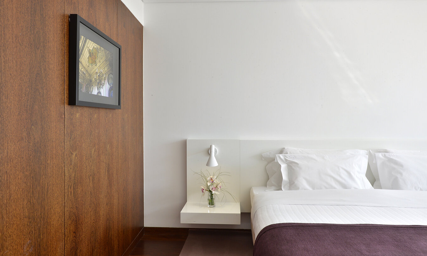 La Habitación Clásica Plus de la Pousada Palácio Estoi tiene una cama matrimonial, una mesa de noche y un cuadro en la pared