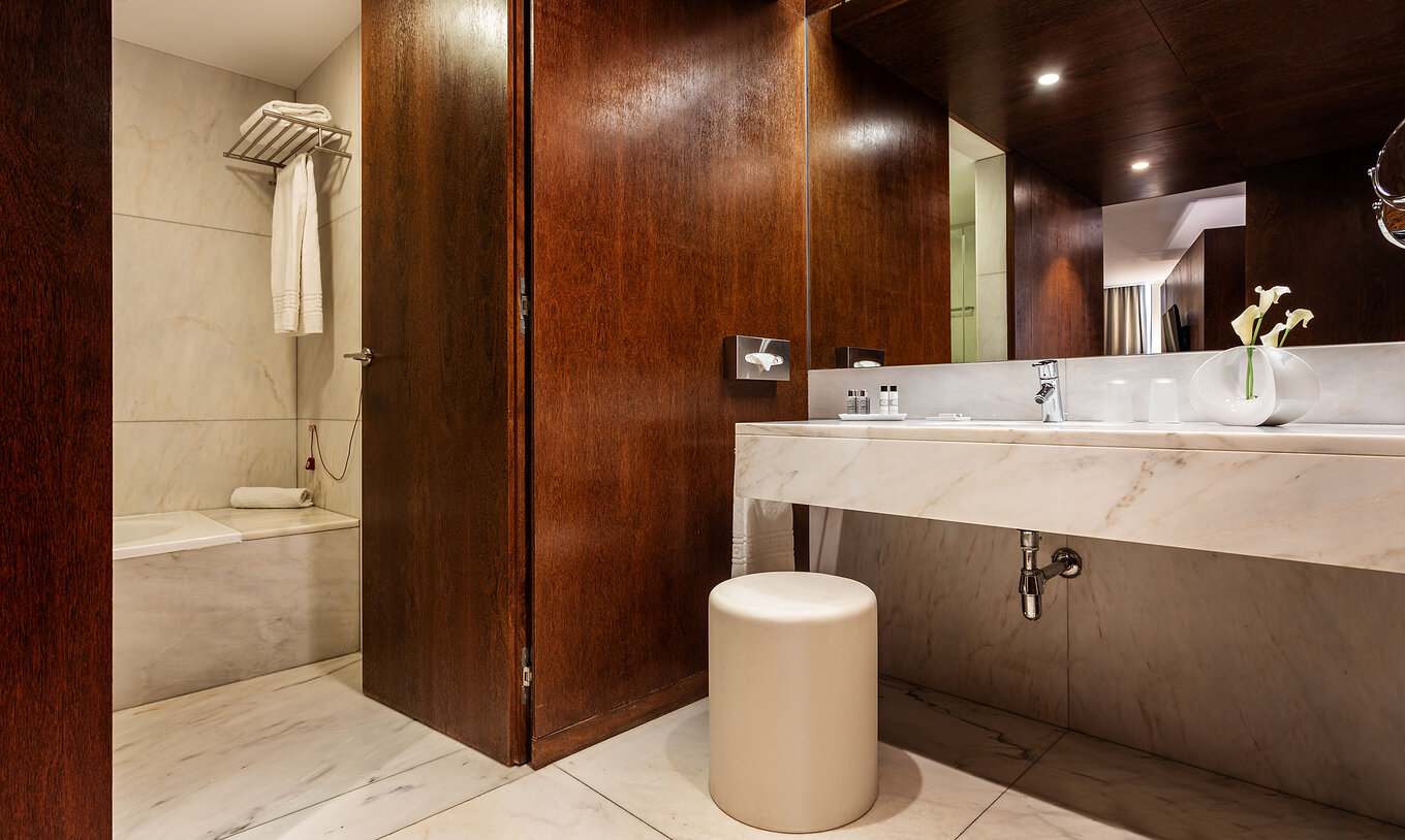 La Suite Standard de la Pousada Palácio Estoi tiene un baño con lavabo, espejo, amenities y un banco