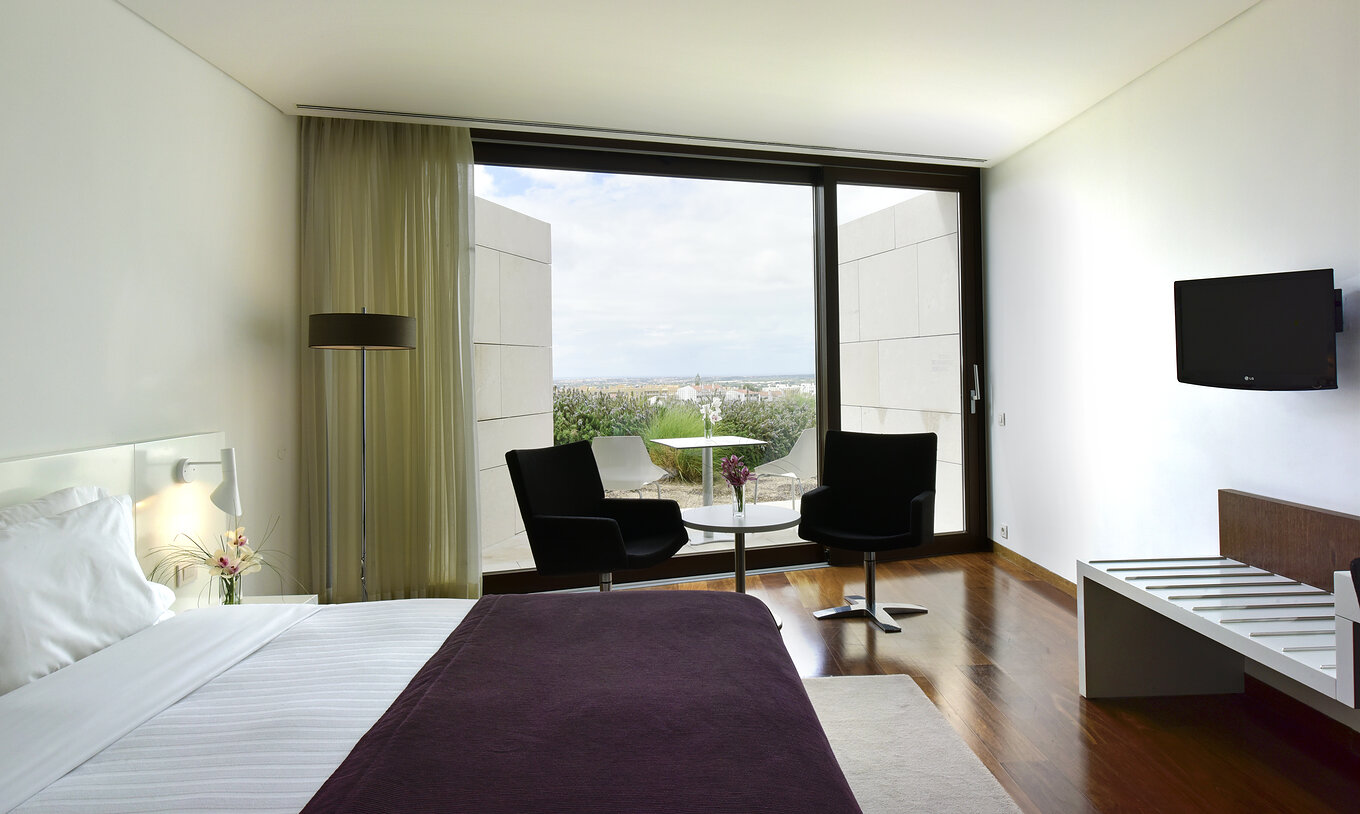 El Superior Premium View de la Pousada Palácio Estoi tiene una mesa con dos sillas, una ventana y una televisión