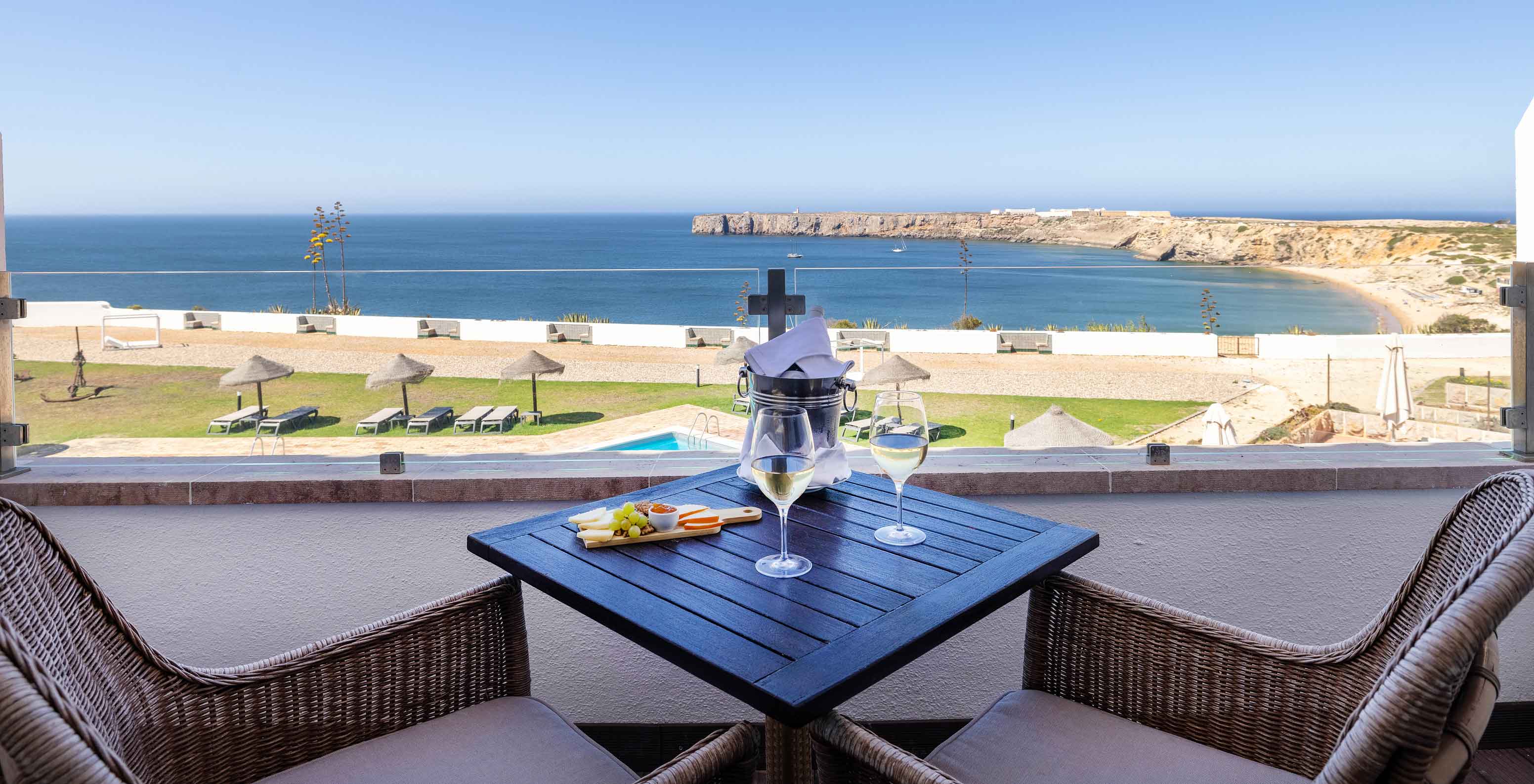 La Suite Especial de la Pousada Sagres tiene un balcón con mesa y silla, con vistas a la piscina exterior y al mar