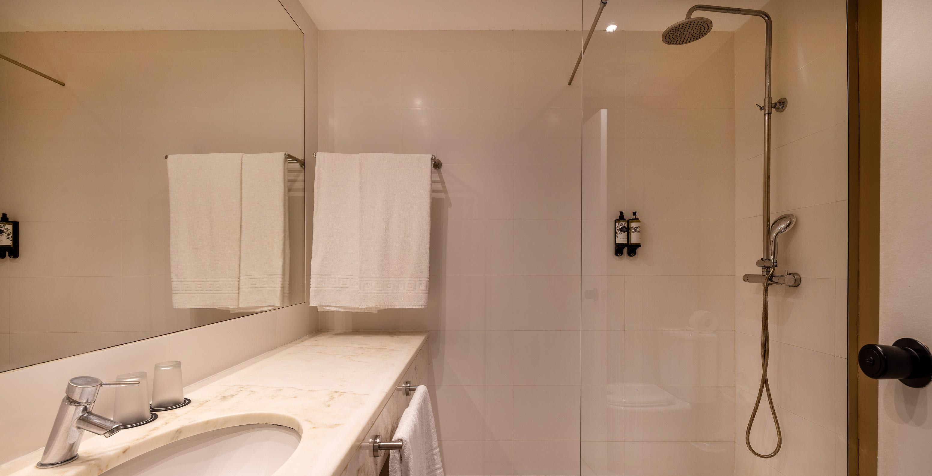 La Suite Especial de la Pousada Sagres tiene un baño con un gran espejo sobre el lavabo, ducha y toallas