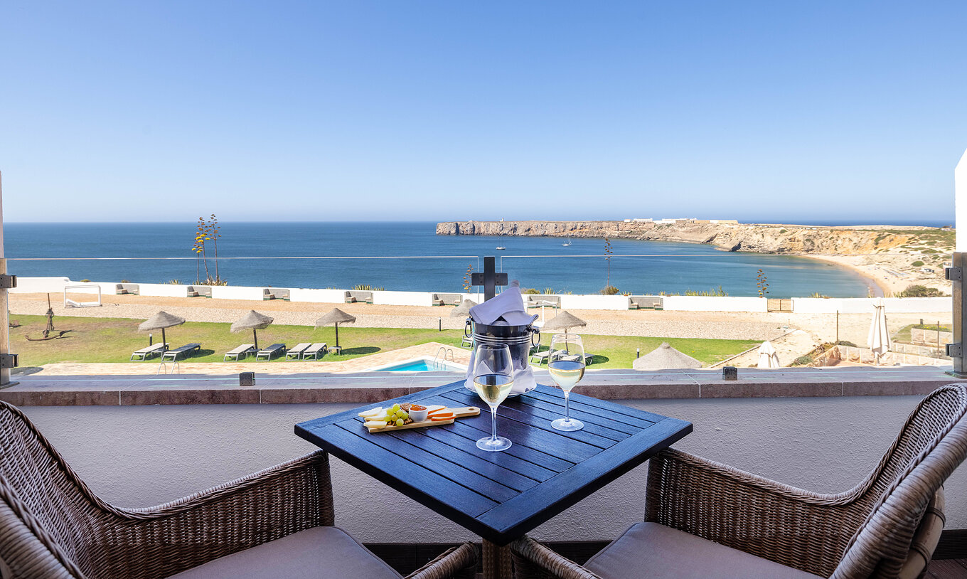 La Suite Especial de la Pousada Sagres tiene un balcón con mesa y silla, con vistas a la piscina exterior y al mar