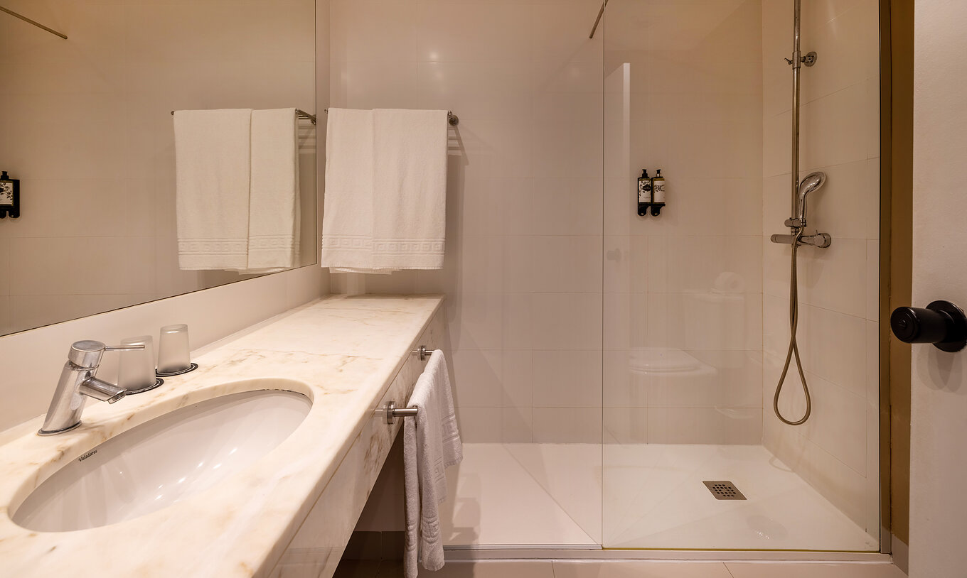 La Suite Especial de la Pousada Sagres tiene un baño con un gran espejo sobre el lavabo, ducha y toallas
