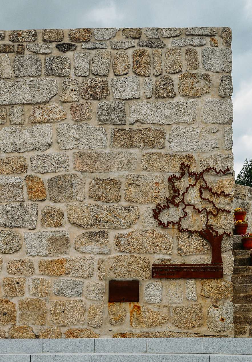 Muro de piedra con escultura metálica junto a Pousada Convento Belmonte, Hotel no Centro de Portugal