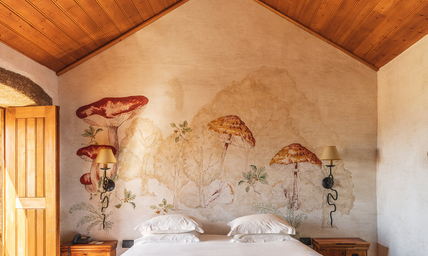 La Suite Superior con Balcón de la Pousada Convento de Belmonte tiene una cama y champiñones dibujados en la pared