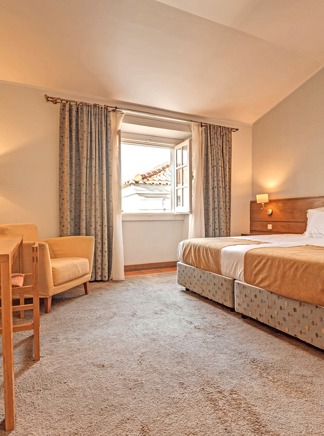 La Habitación Superior Familiar de la Pousada Ourém tiene dos camas juntas con una ventana al lado abierta y vista