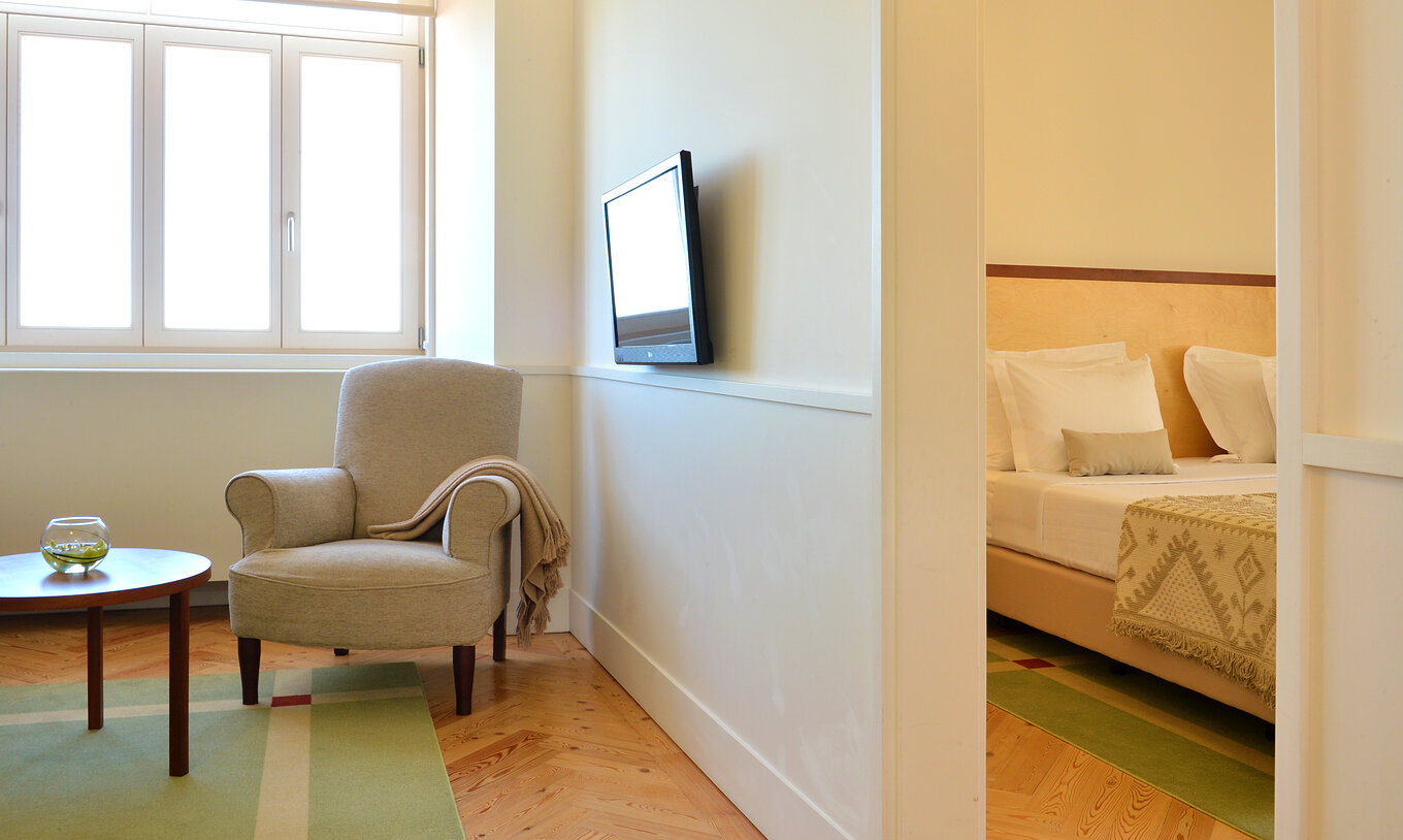 La Large Family & Suite de la Pousada Serra da Estrela tiene un cuarto con cama, una sala con una butaca y una televisión