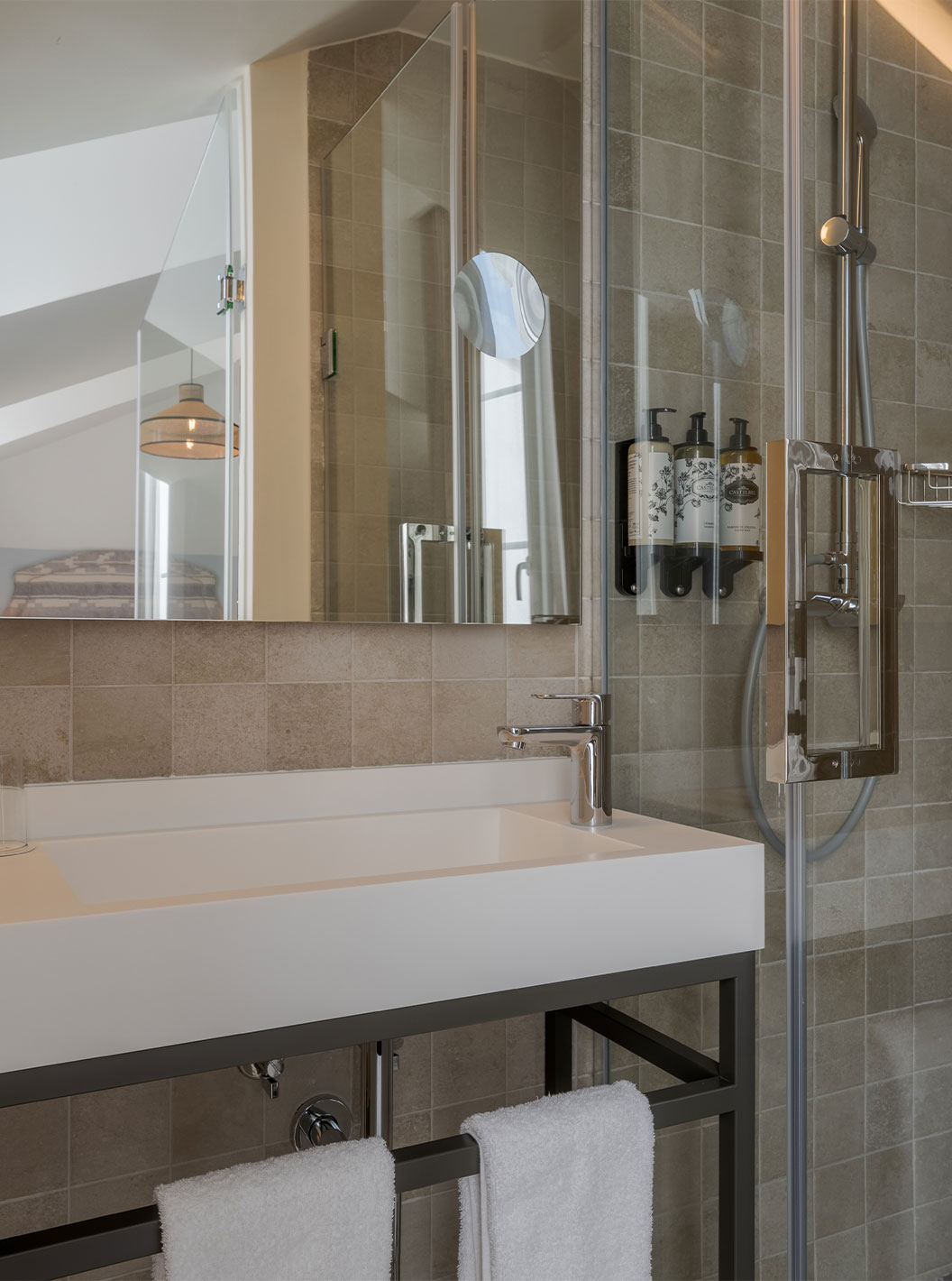 La Junior Suite River View de la Pousada Alfama tiene una ducha a ras de suelo y un amplio lavabo en el baño