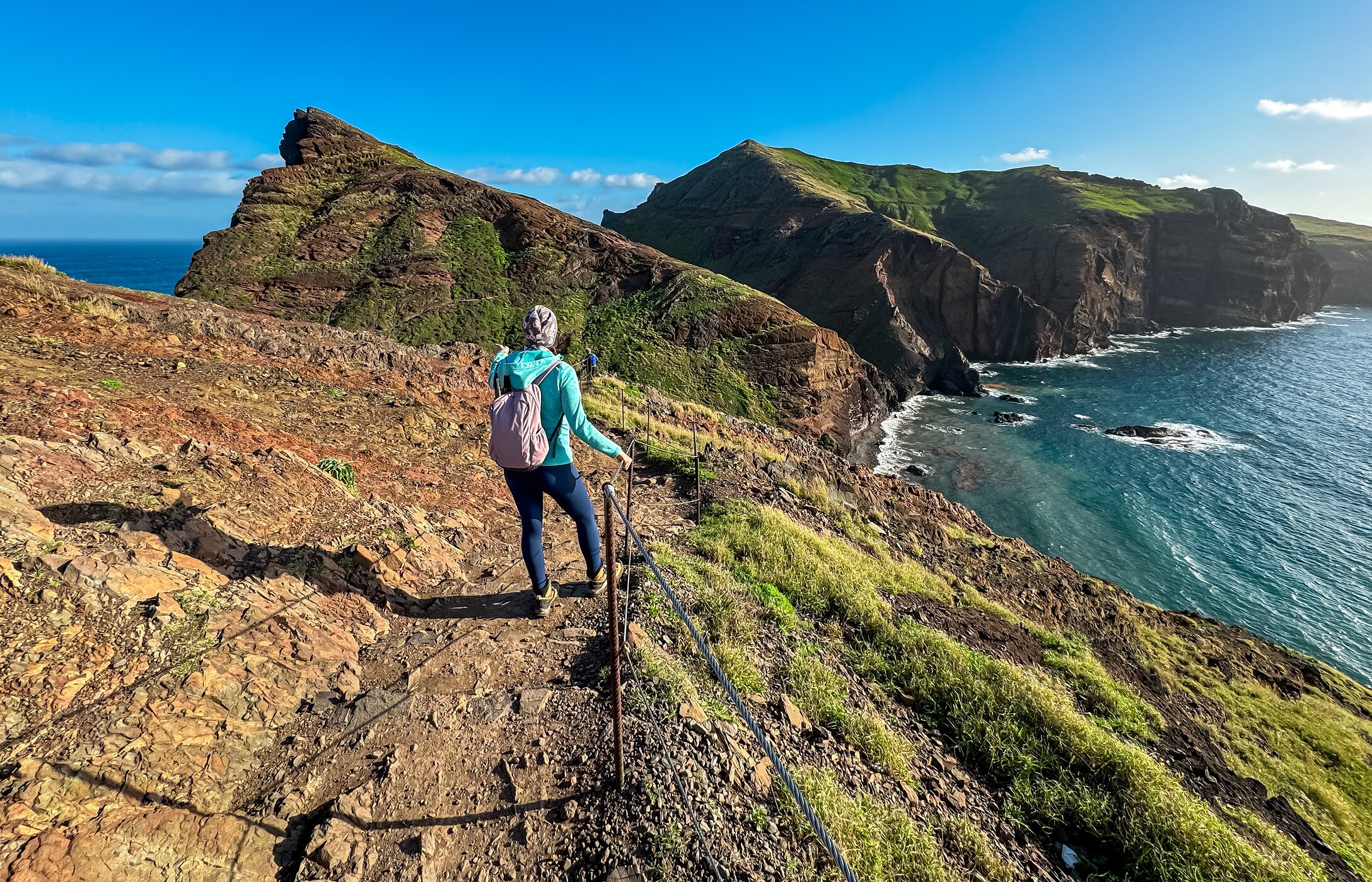 Señora haciendo senderismo en Funchal, con vista a la montaña y al océano Atlántico