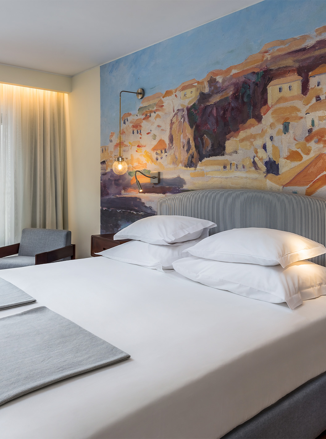 El Cuarto Deluxe Superior Familiar con Vista a la Bahía del Pestana Churchill Bay tiene tonos grises con cama doble y balcón