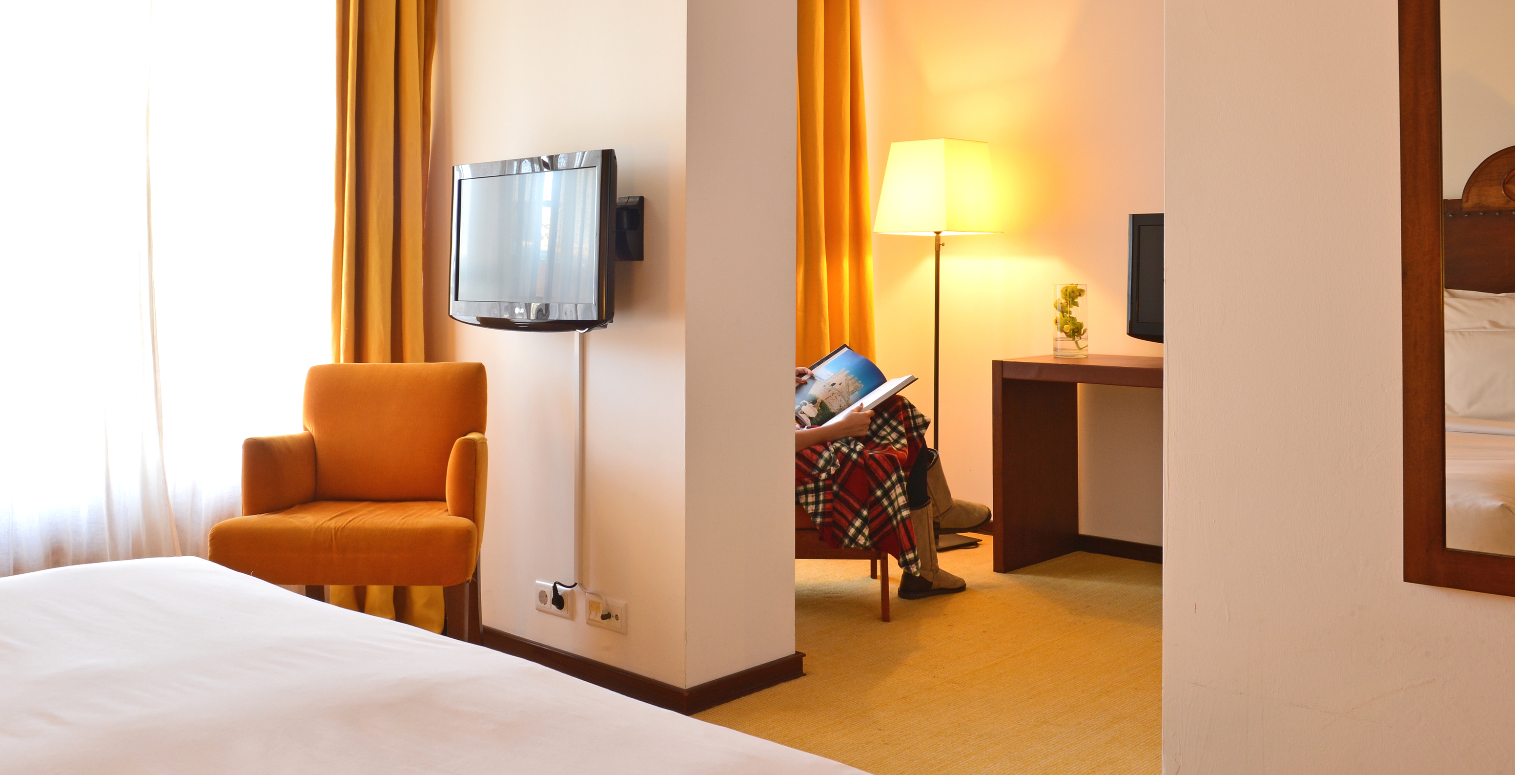 La Suite Standard de la Pousada Caniçada - Gerês tiene una televisión, un sillón amarillo y un rincón de lectura al fondo