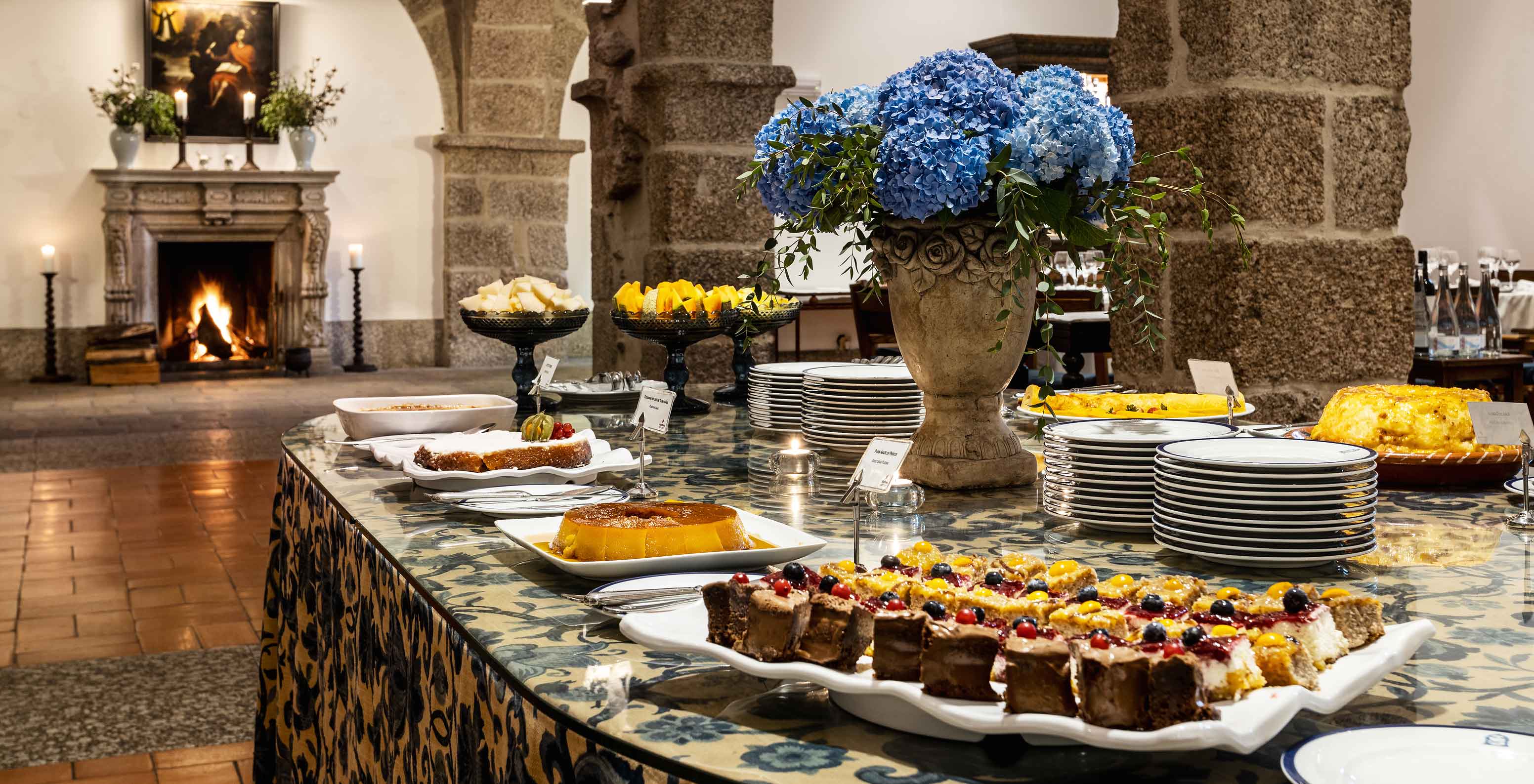 El restaurante D. Mafalda de la Pousada Mosteiro de Guimarães tiene una mesa larga con varios postres típicos y deliciosos