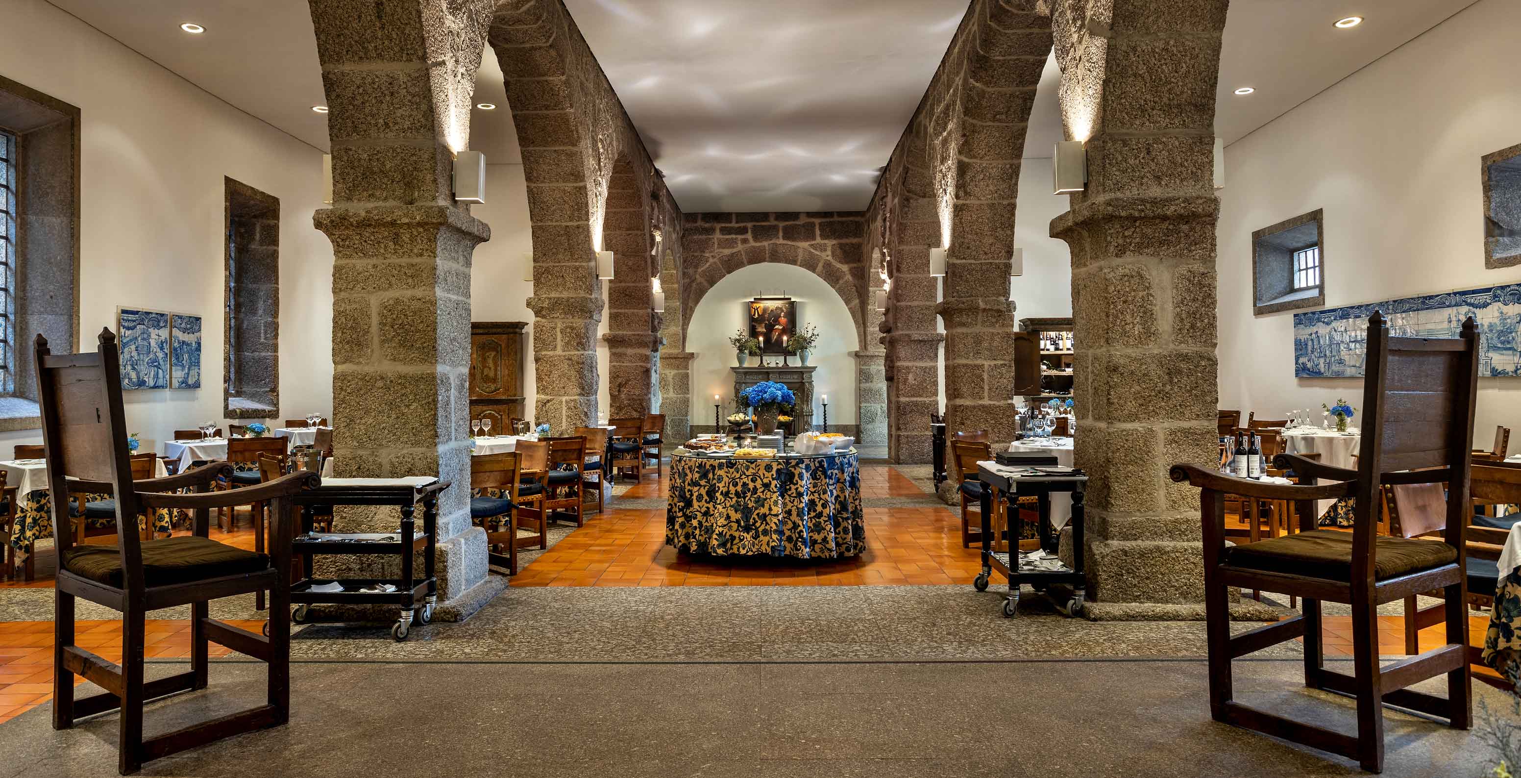 El restaurante D. Mafalda de la Pousada Mosteiro de Guimarães tiene una mesa buffet en el centro de la sala y mesas alrededor