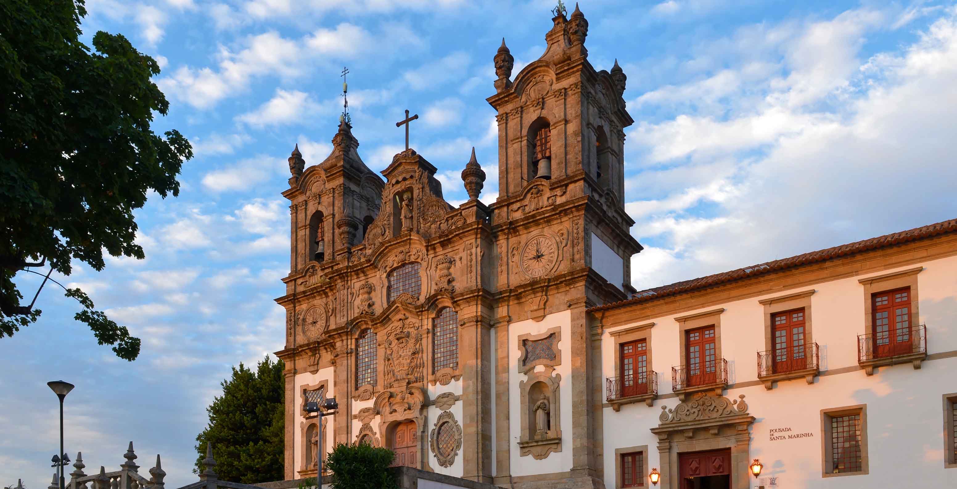 Vista exterior de la fachada de la Pousada Mosteiro de Guimarães, un edificio imponente con la iglesia al norte