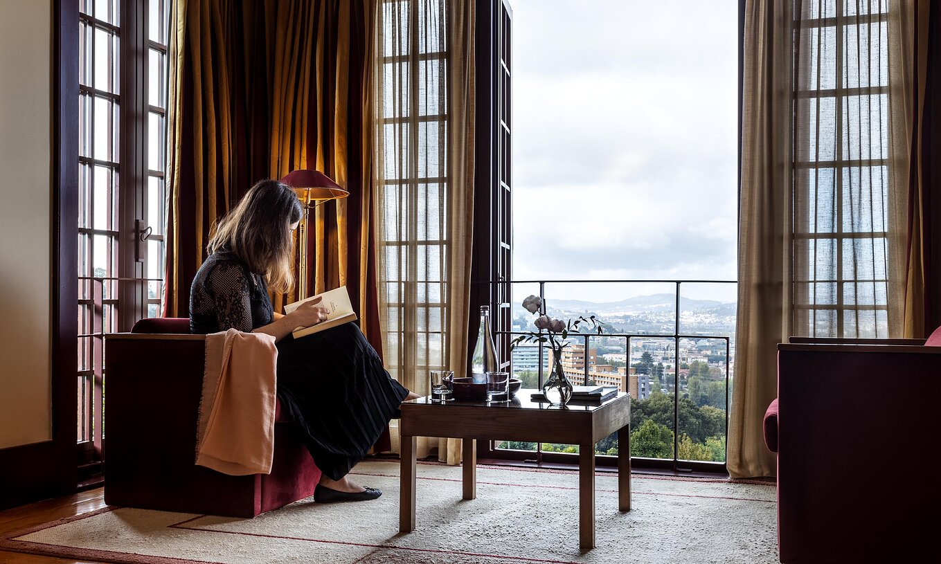 El Cuarto Superior de la Pousada Mosteiro Guimarães tiene un sofá y una ventana grande con vista a la ciudad