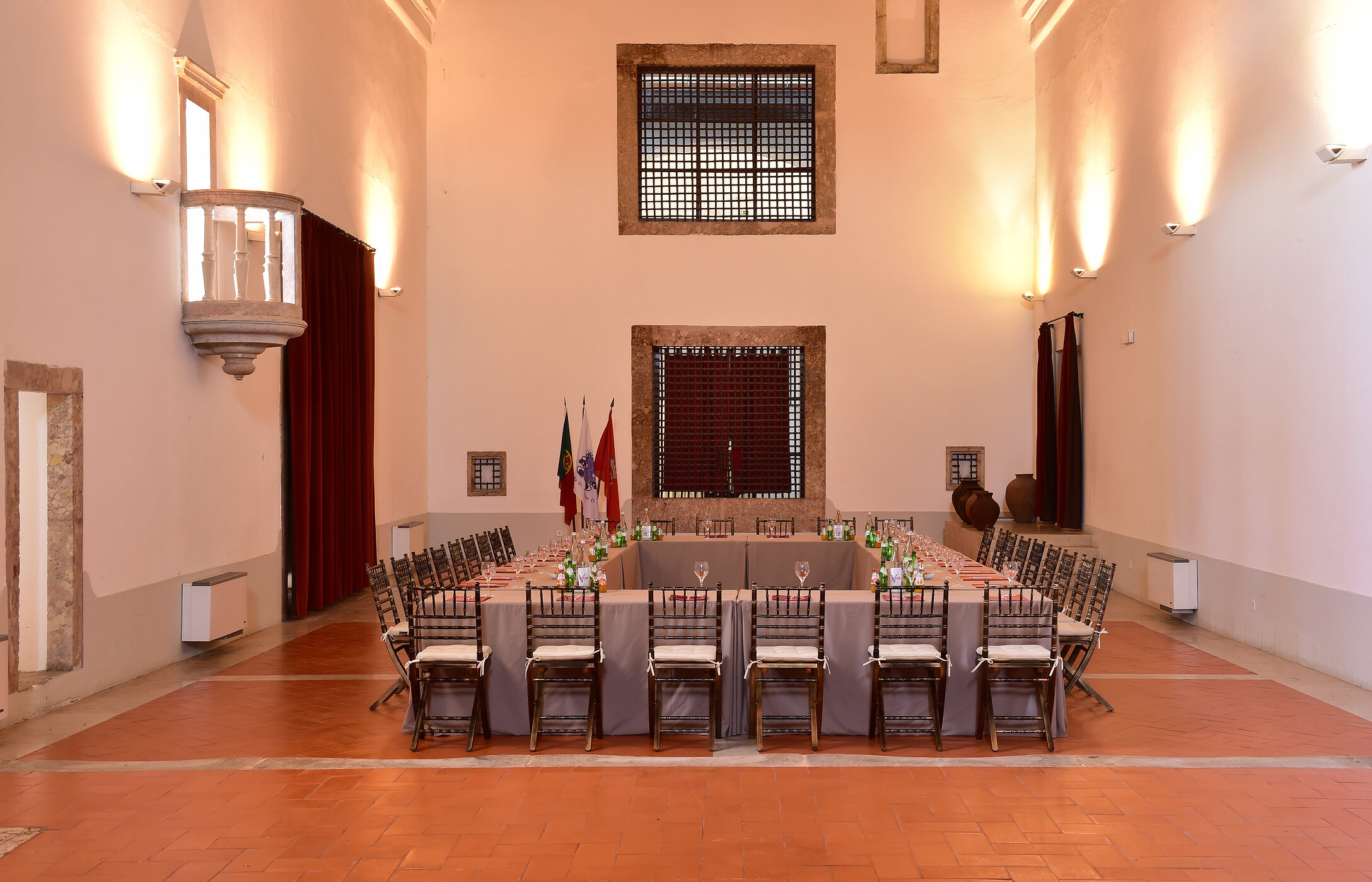 Sala histórica para reuniones o conferencias, con paredes altas y una gran mesa rectangular con sillas y bebidas